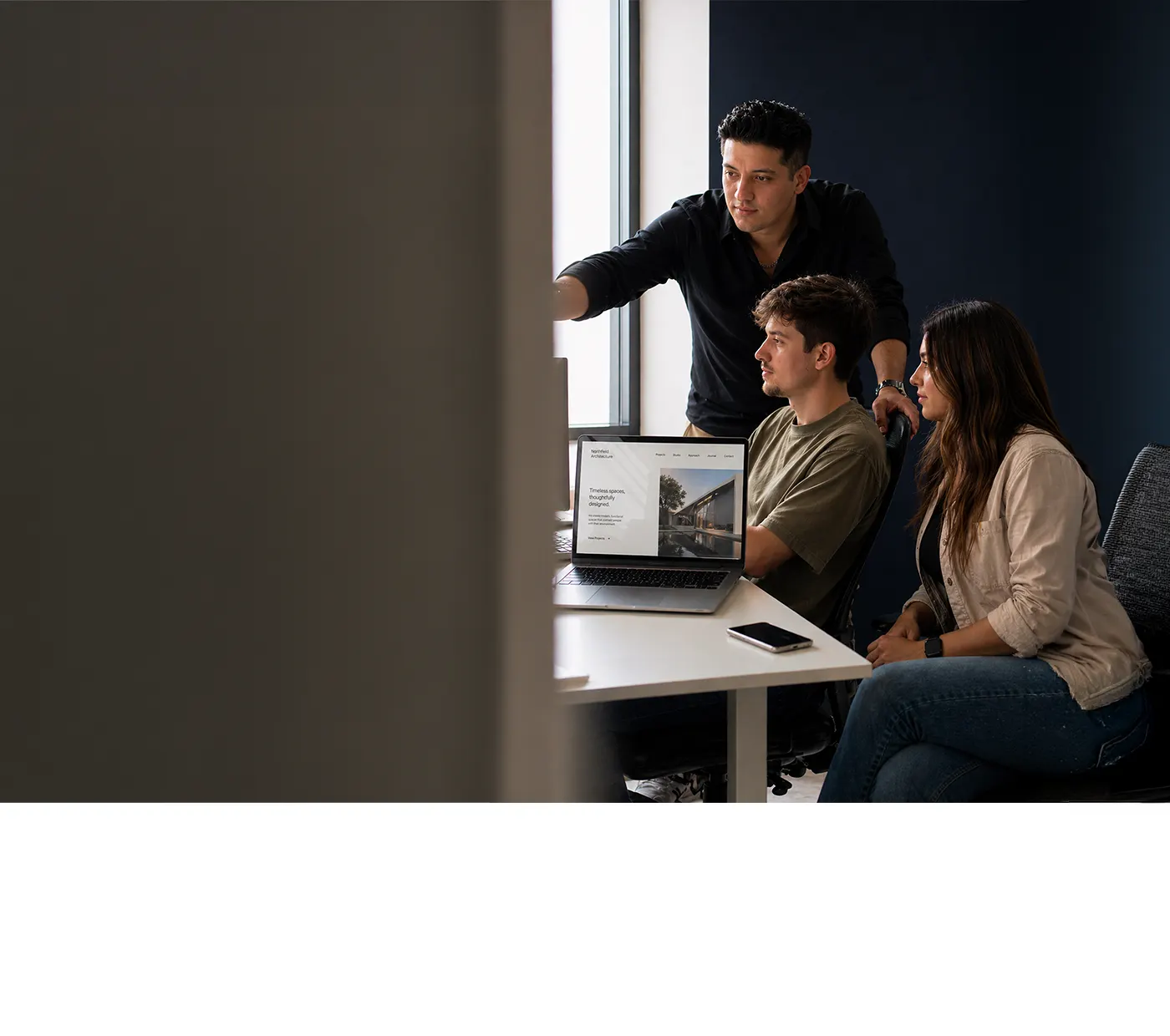 Three consultants reviewing a website on a laptop
