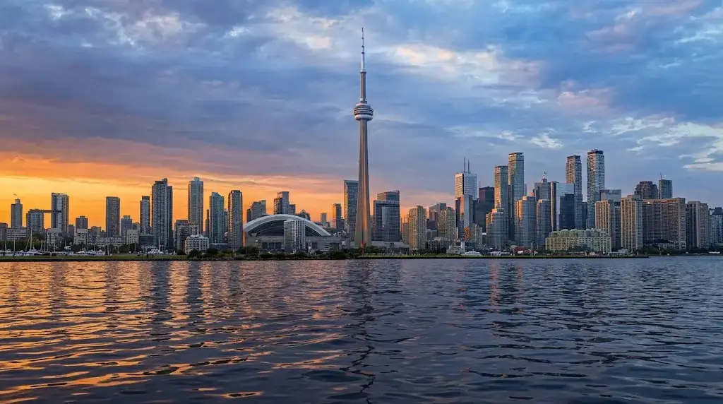The Toronto skyline and CN Tower over the lake at sunset