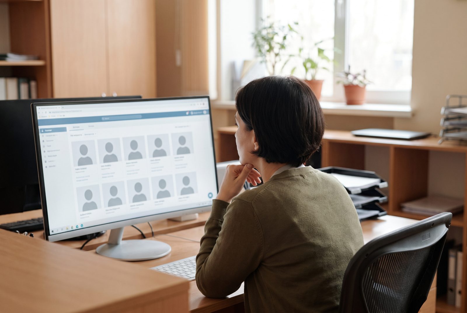 Une recruteuse face à un écran affichant une longue liste de profils.