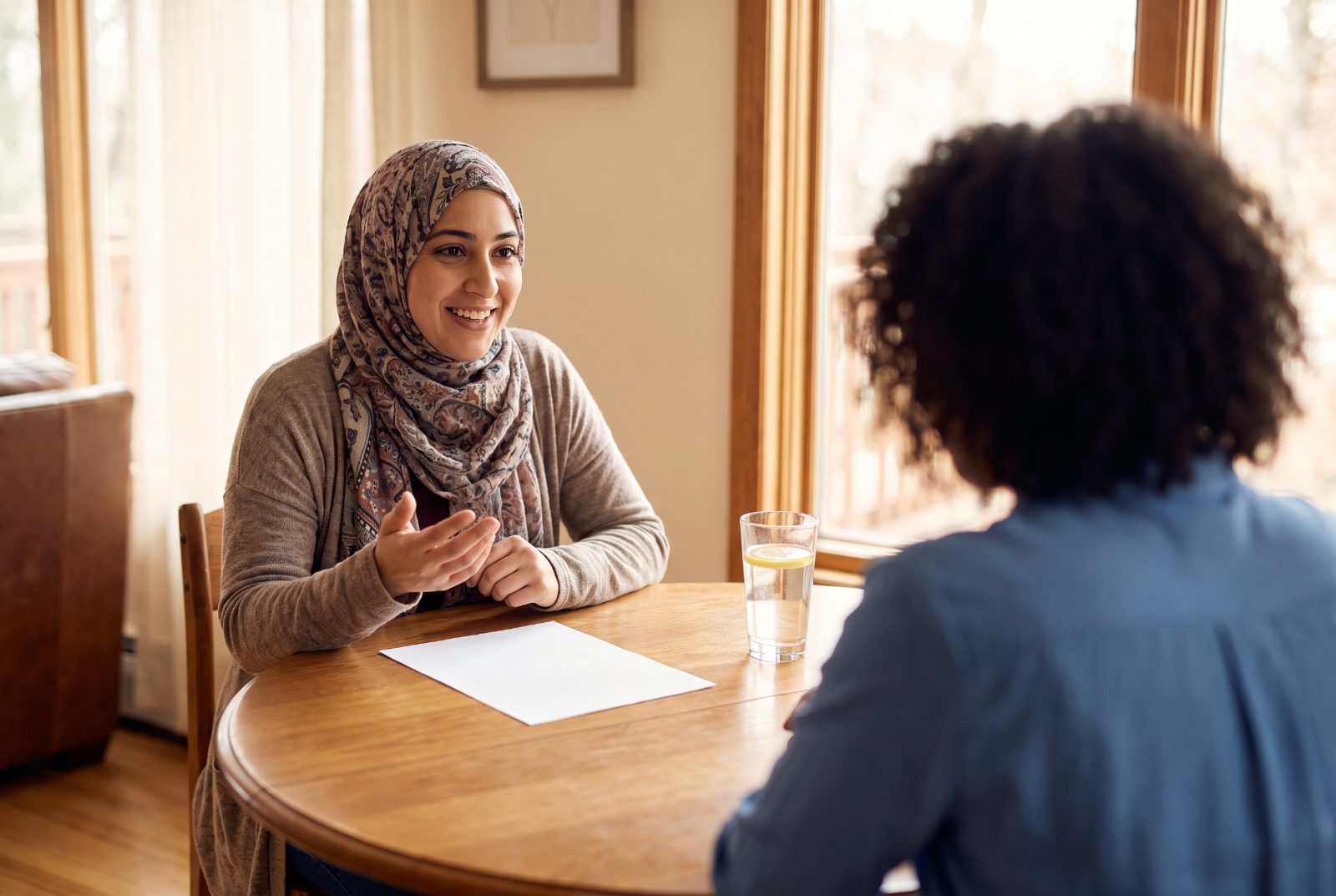 Une candidate souriante échange avec une recruteuse lors d'un entretien détendu.
