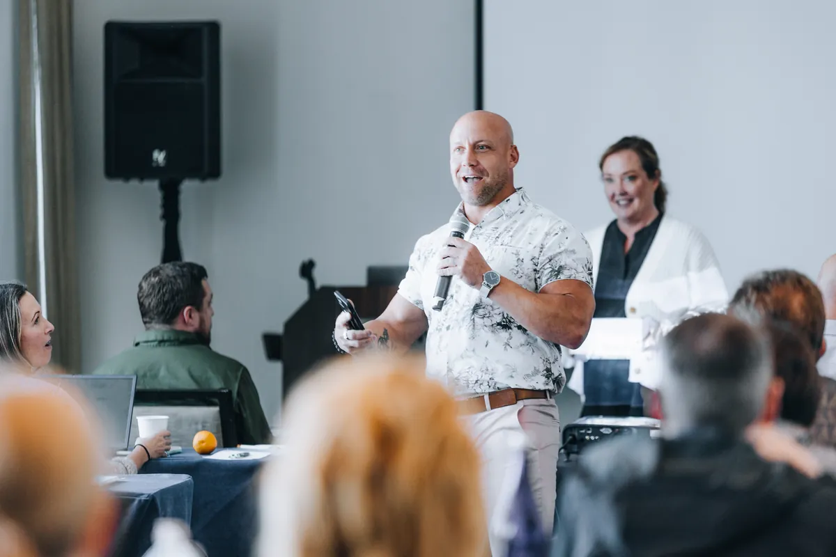A MediSkill instructor with a microphone teaches a room of clinicians