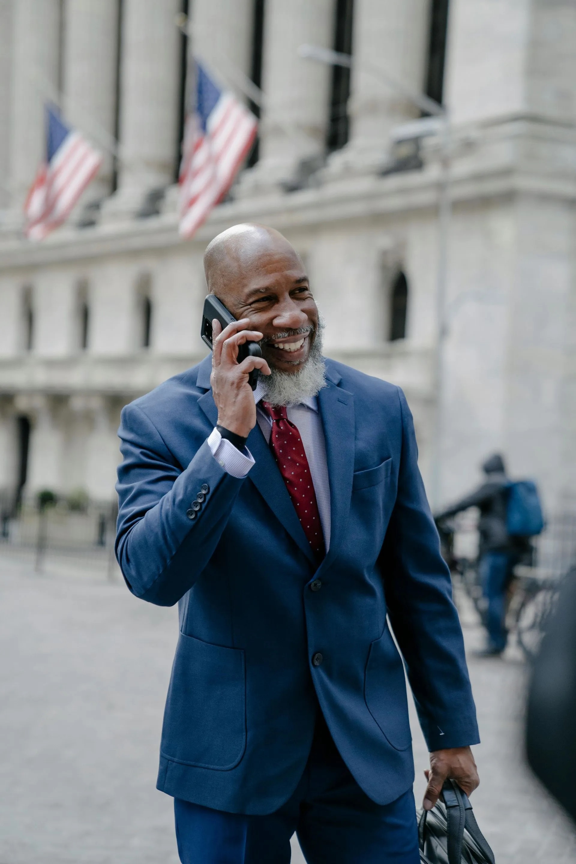 Man in a suit smiling on a phone call