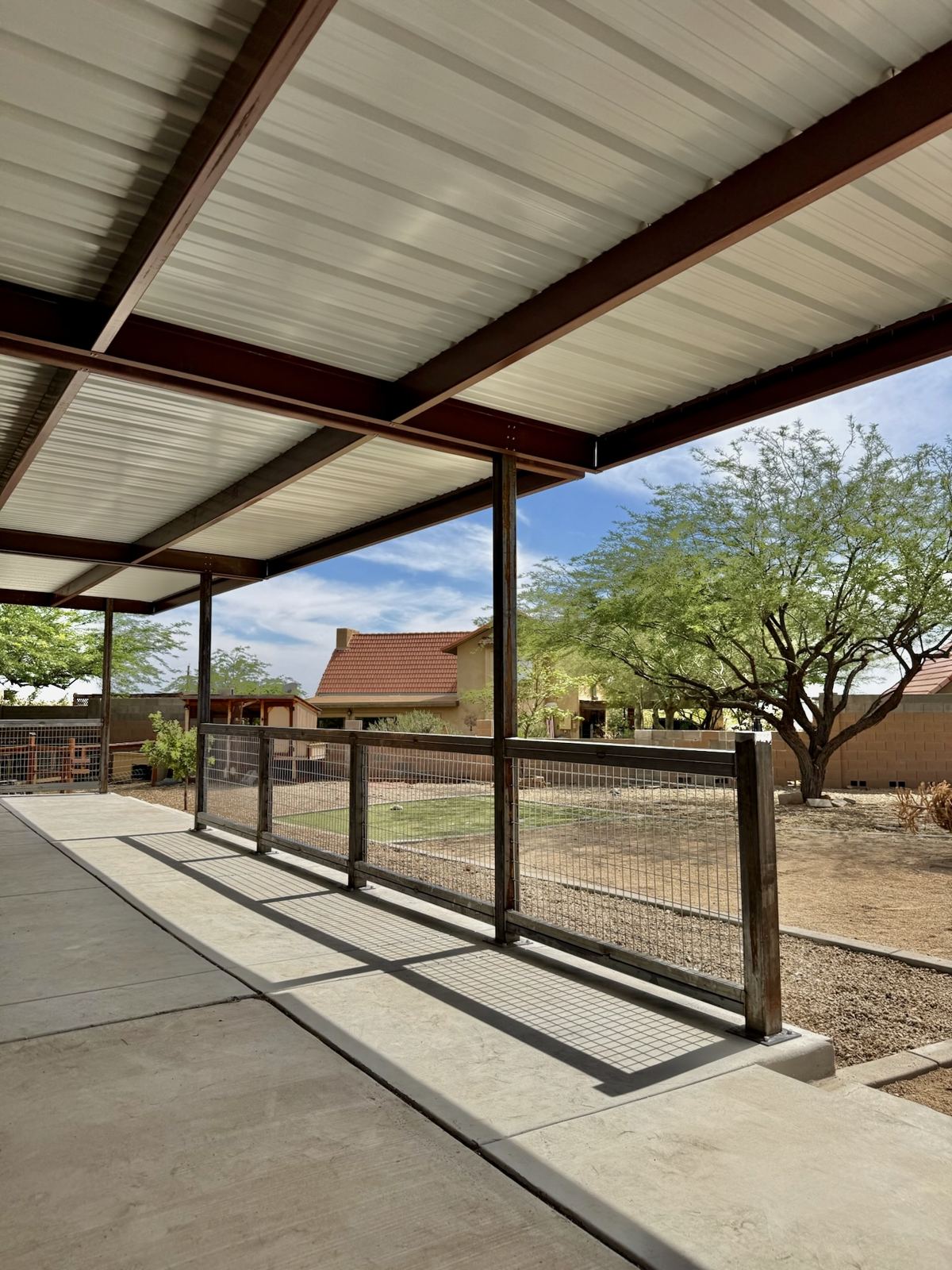 Covered patio with steel posts and wire railing