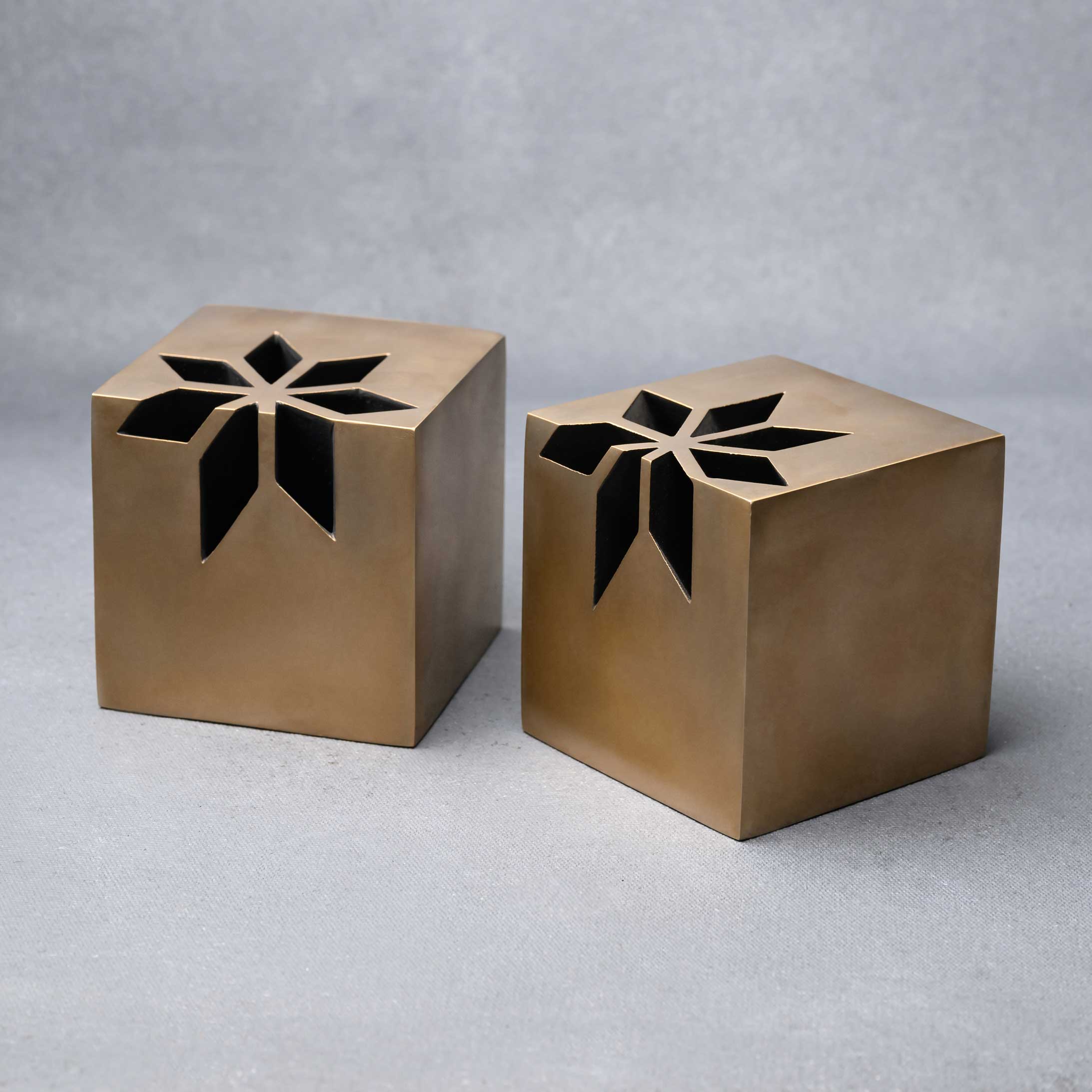 Two solid brass prizes with the logo design cut out of the prize itself.