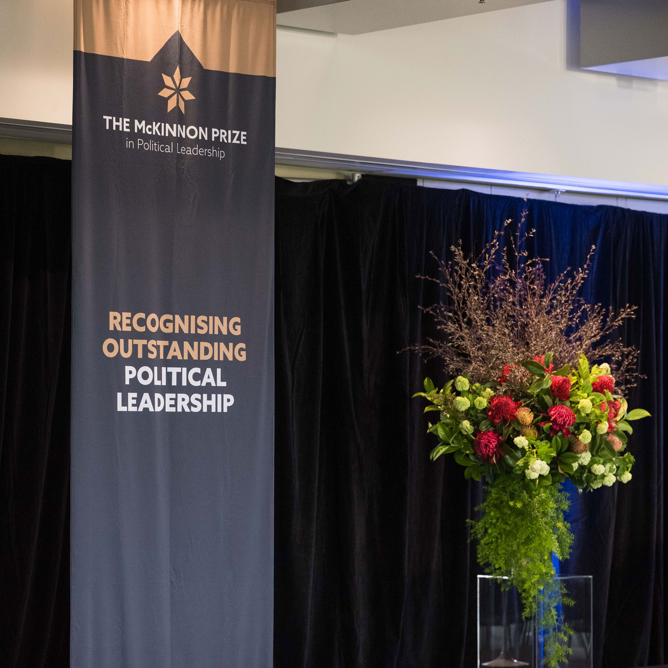 McKinnon Prize three metre long vertical branded banner alongside flower decoration.