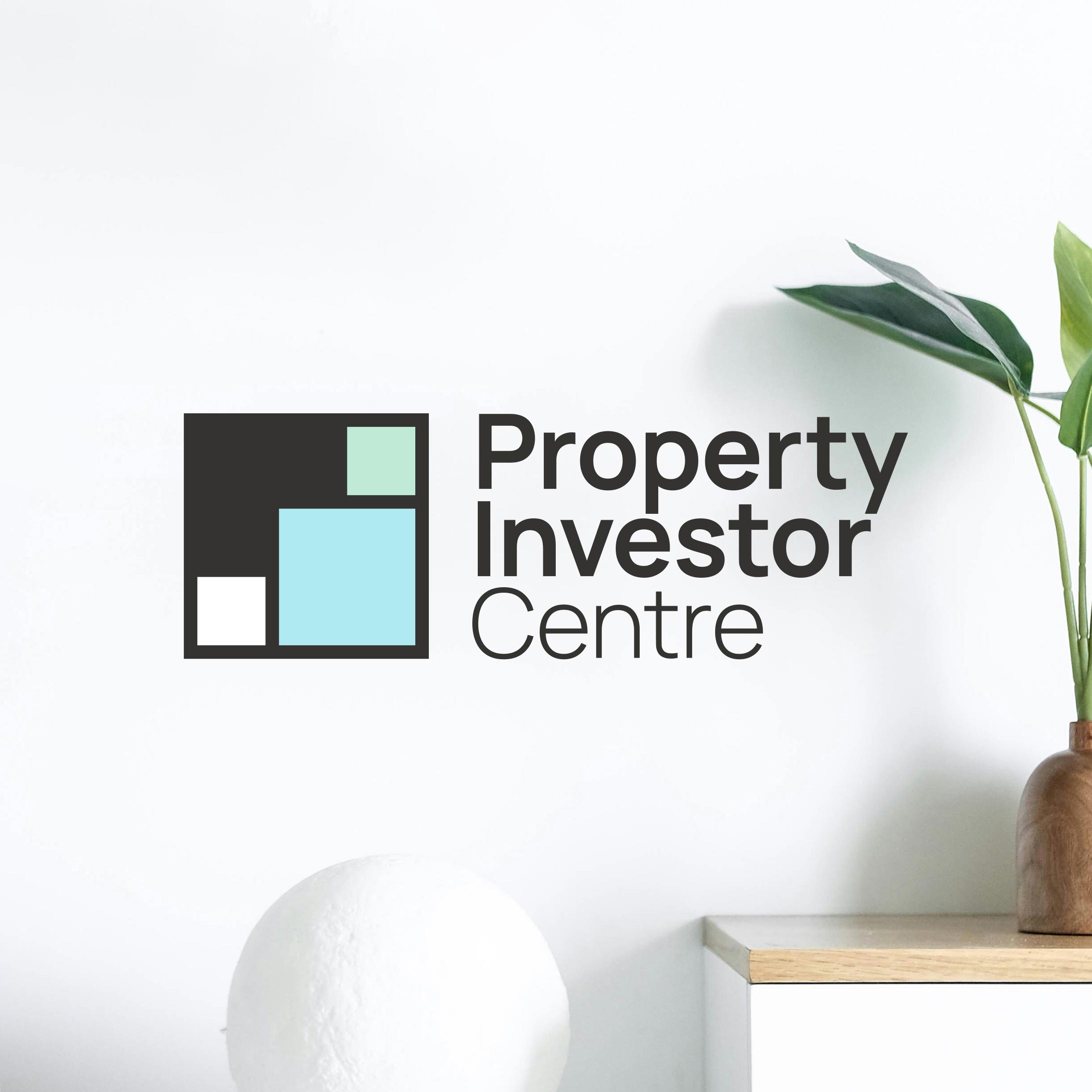 Property Investor Centre logo in centre of the image with a plant on right, and white circle ornament at the bottom of frame.