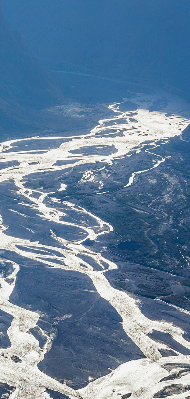 A rivver with multiple shallow streams moving away from the mountains.