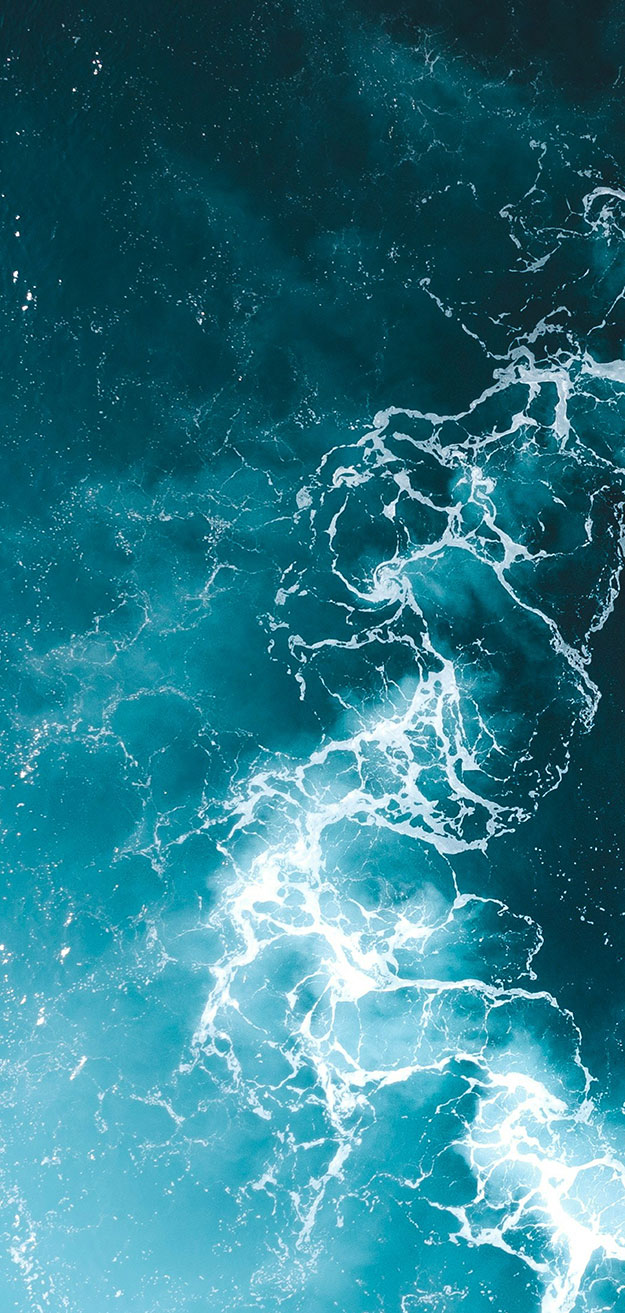 Ocean water interrupted by circular disturbance, with white water.