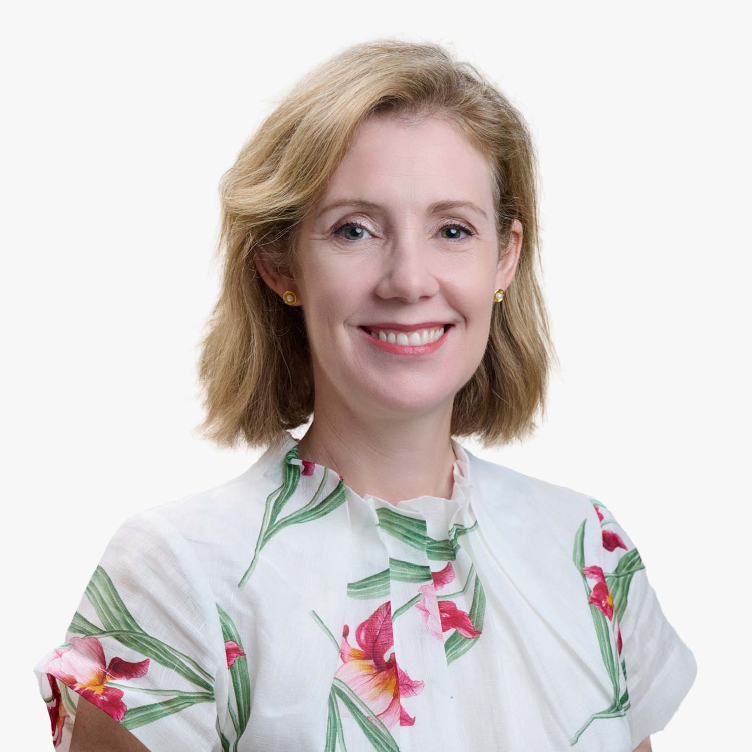 Photo of Naomi Abela wearing a white floral shirt, and with a sandy brown bob