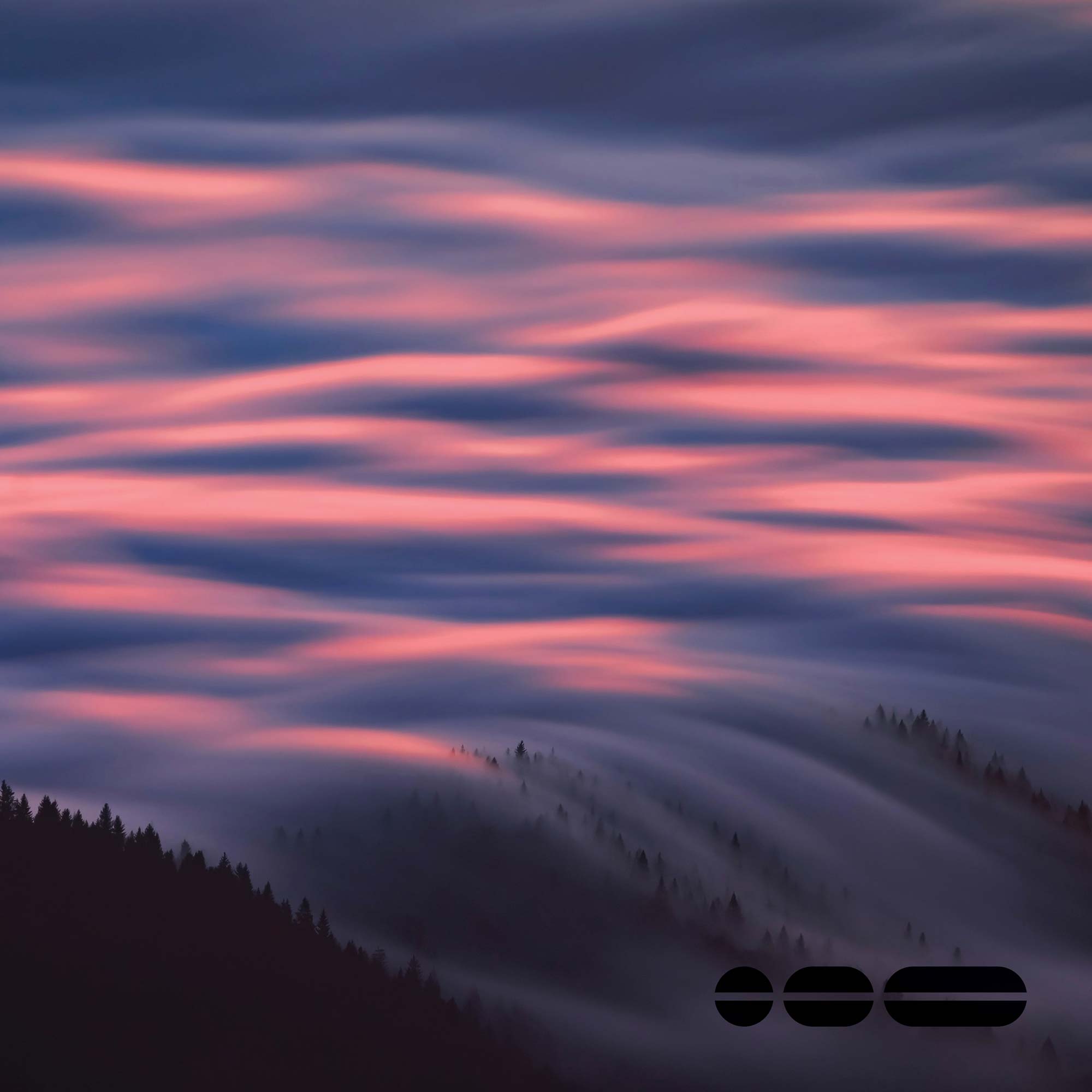 Low-lying clouds draped over the mountainside at sunrise.