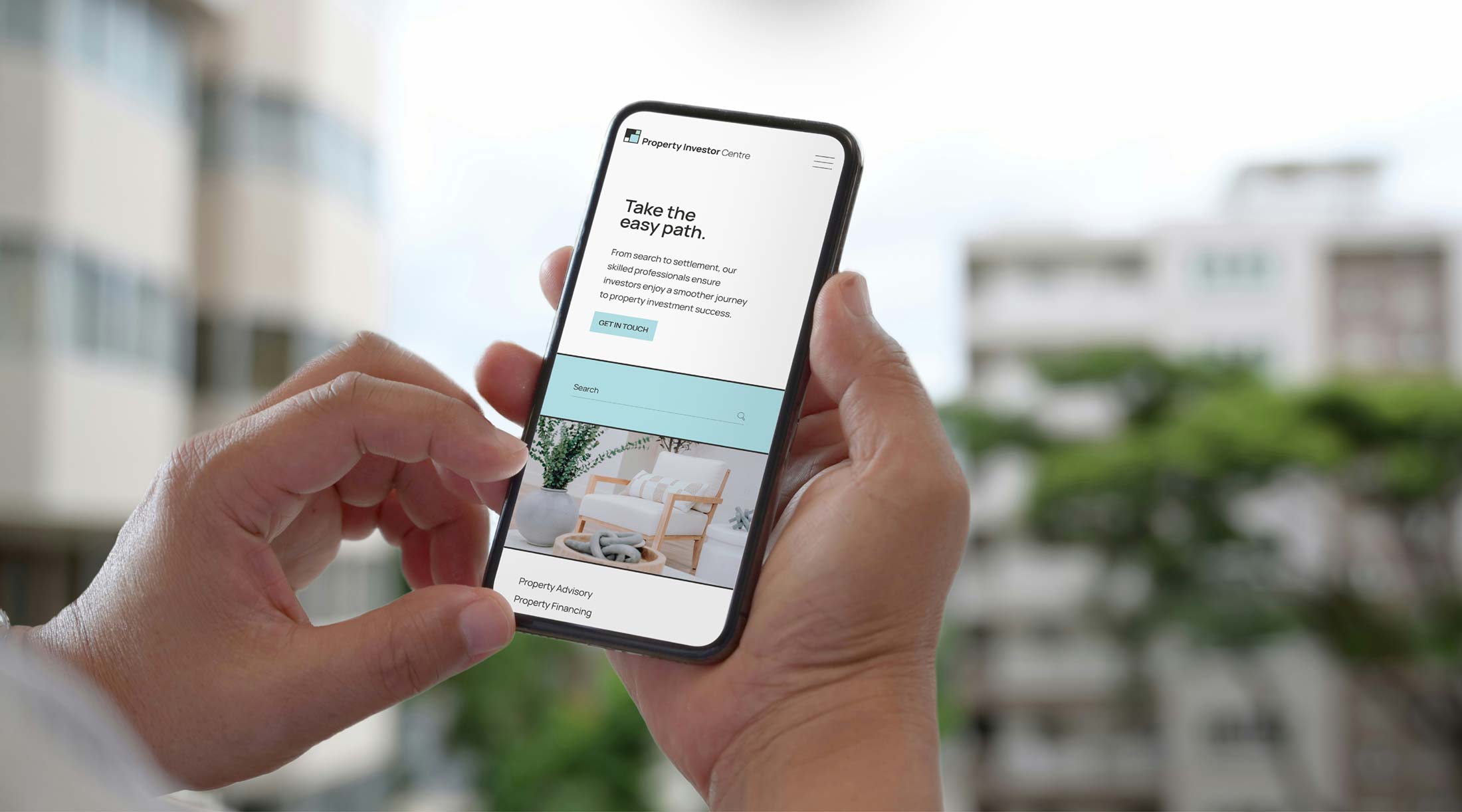 Person holding mobile phone with Property Investor Centre website loaded.