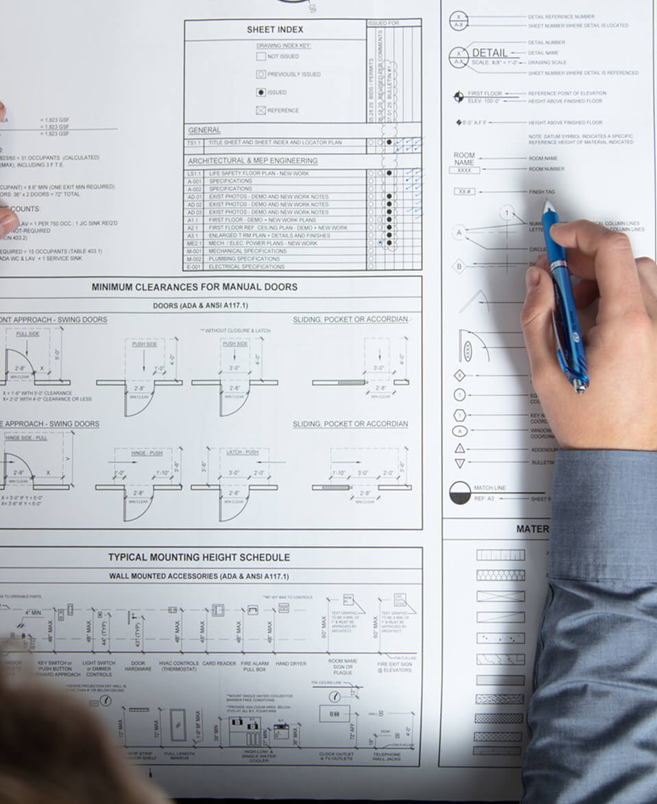 A man reading a blueprint in the office.