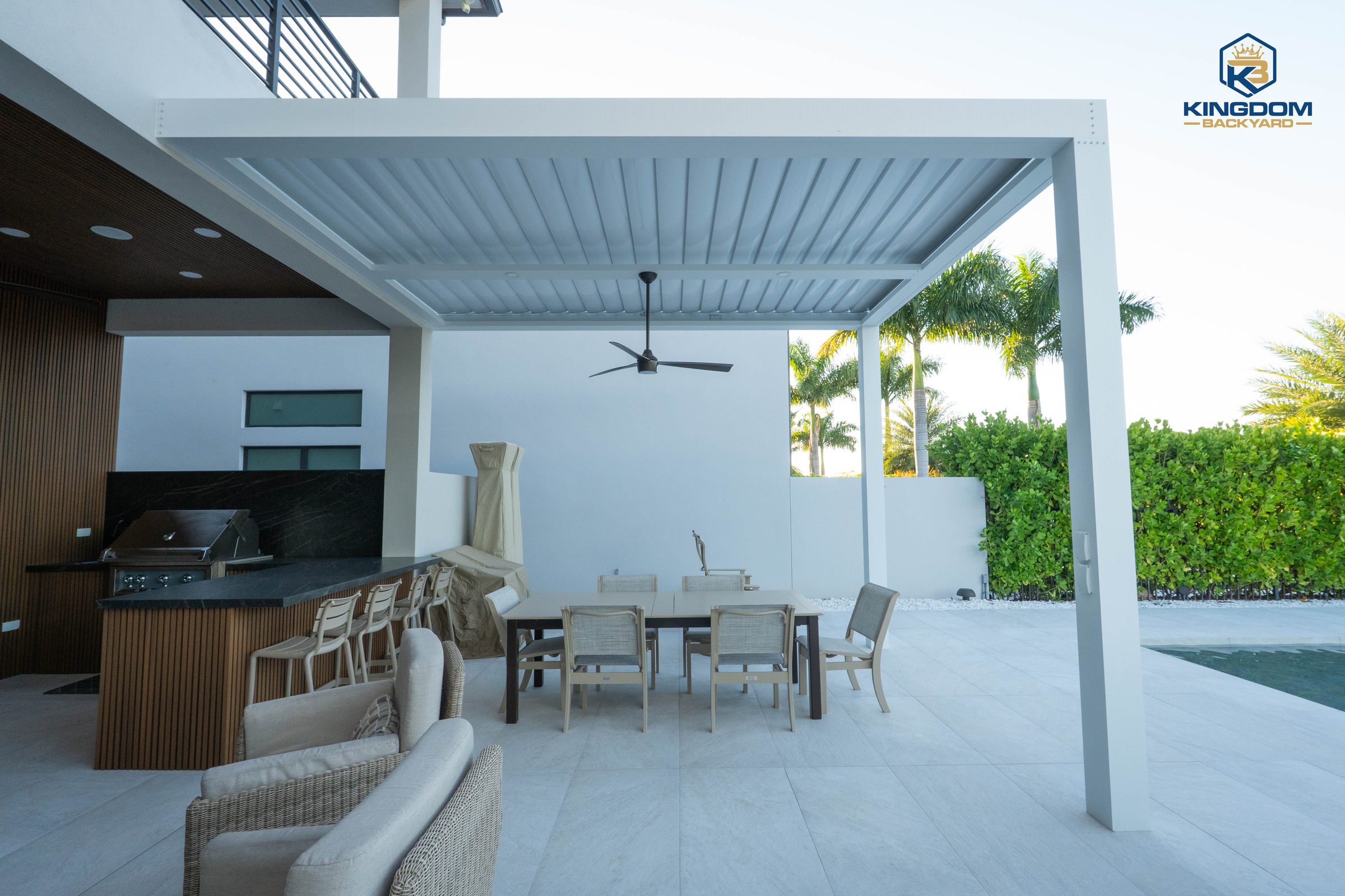 Louvered pergola over an outdoor living and kitchen area