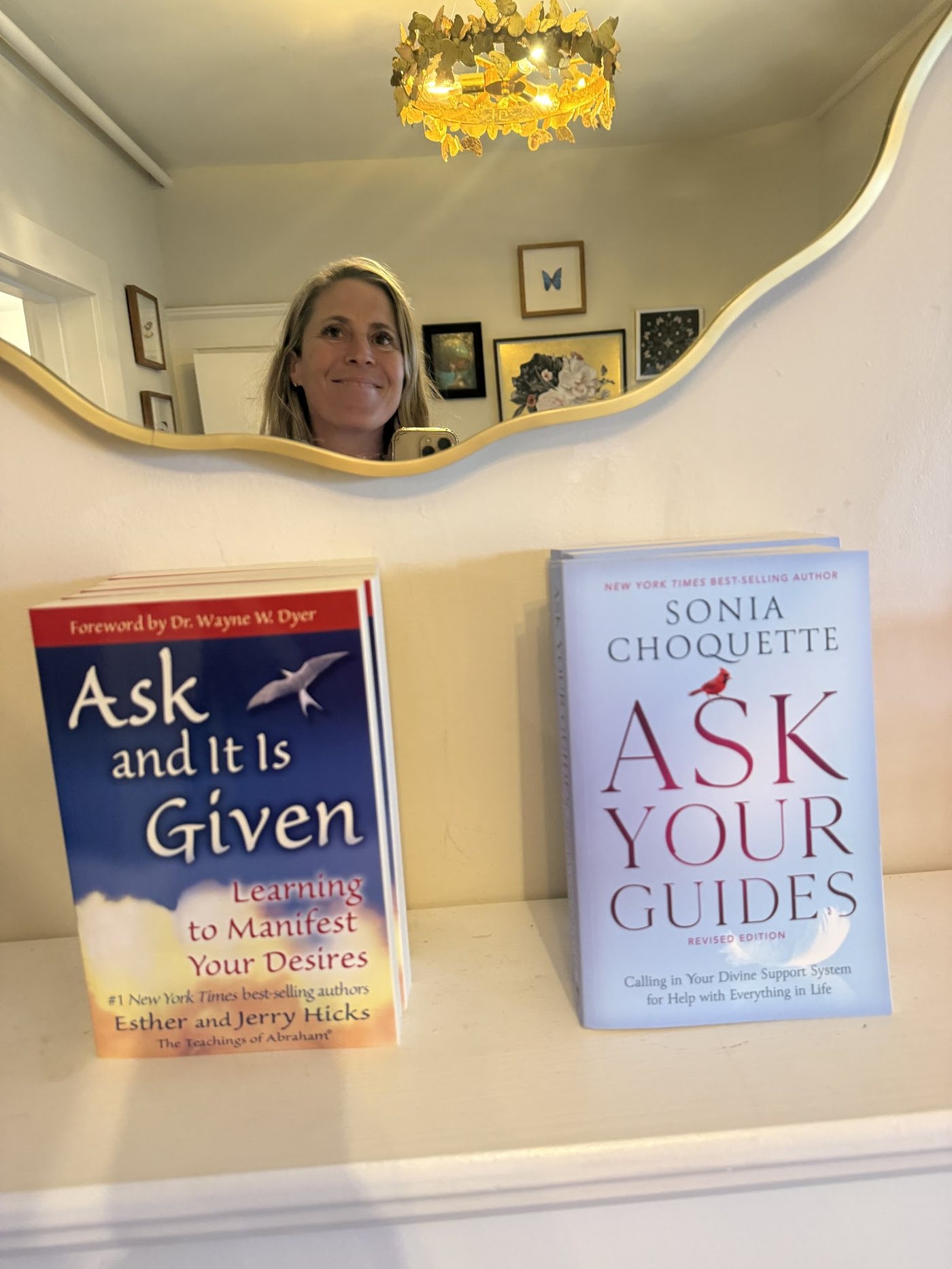 Ask and It Is Given and Ask Your Guides on a shelf beneath a mirror in the Monarch Soul studio
