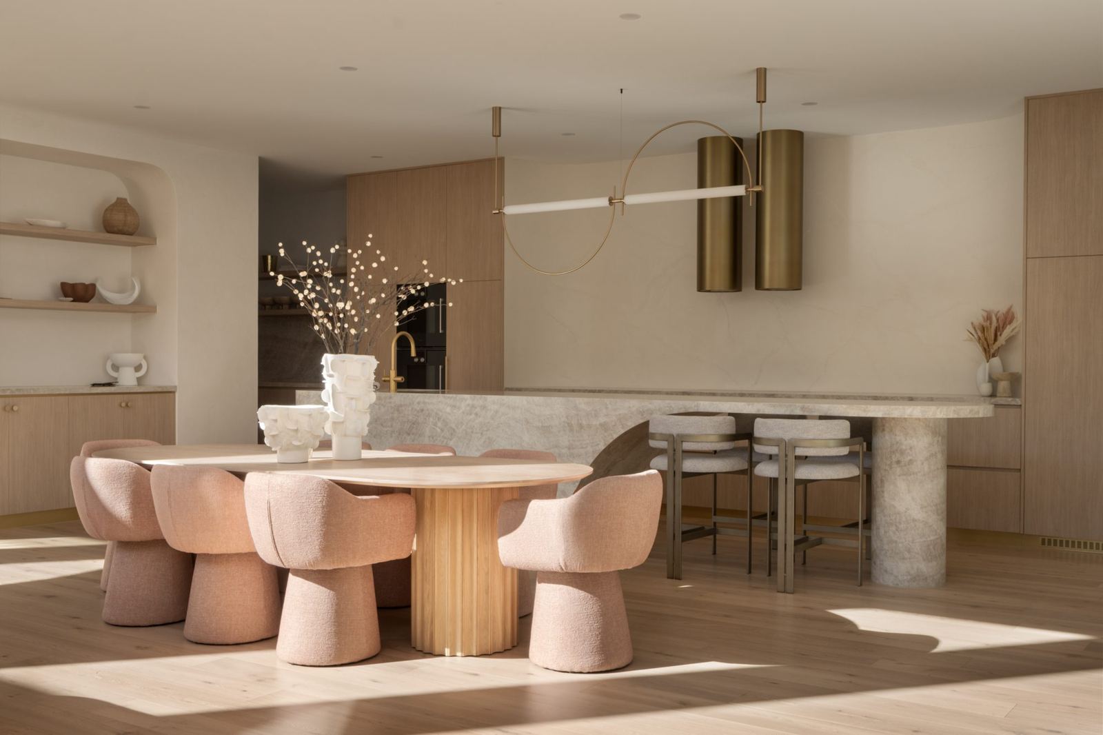 Stone dining table and island with brass pendant lighting