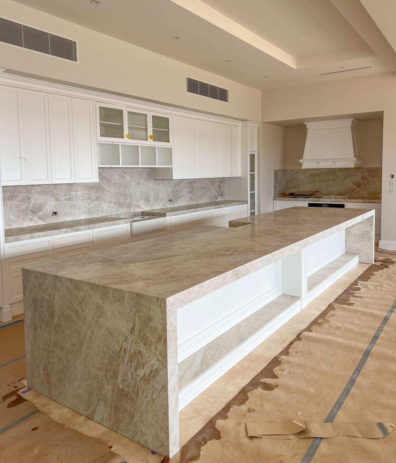 Long natural stone kitchen island with waterfall ends, installed on the Sunshine Coast