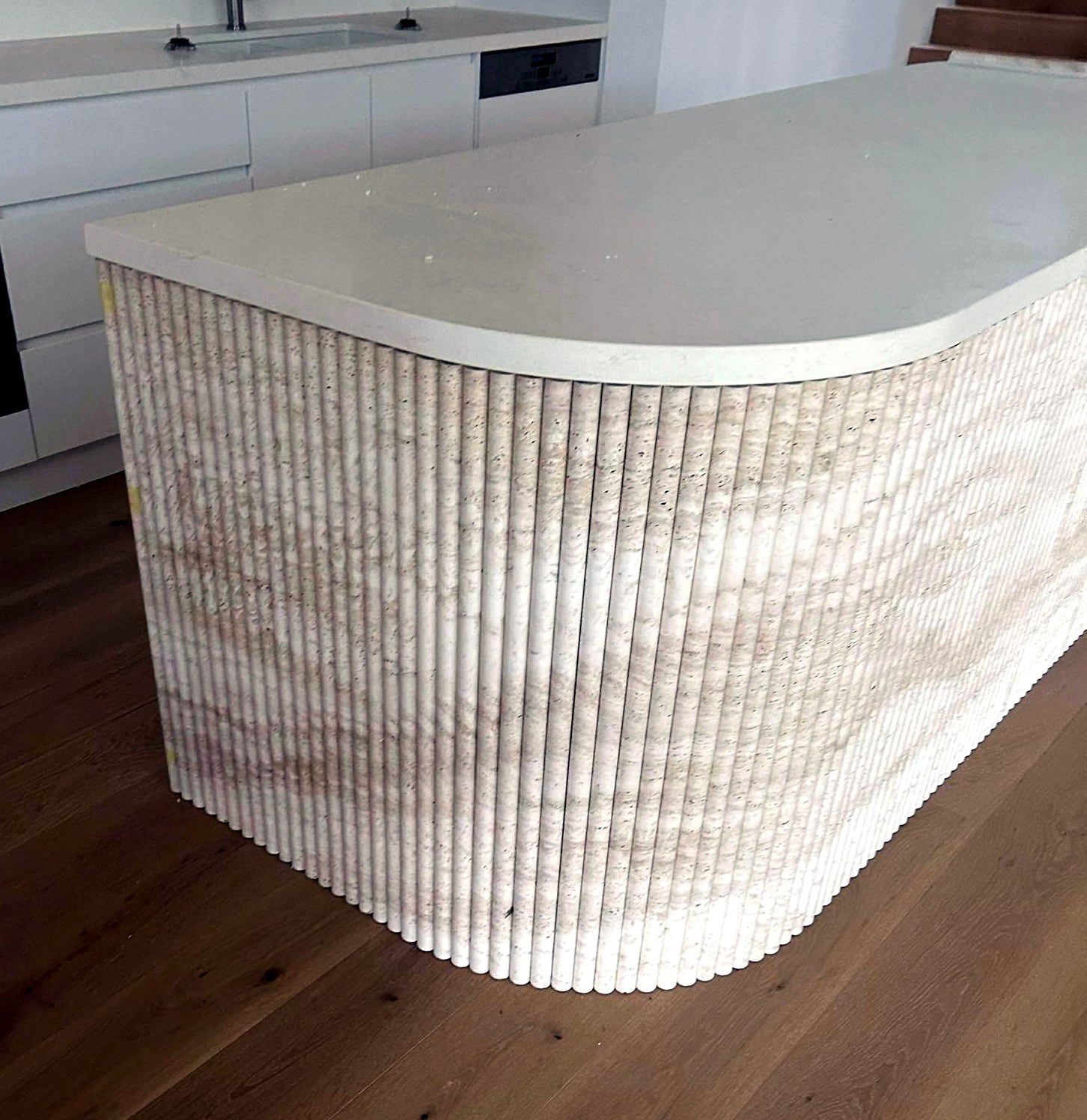 Curved fluted stone kitchen island end