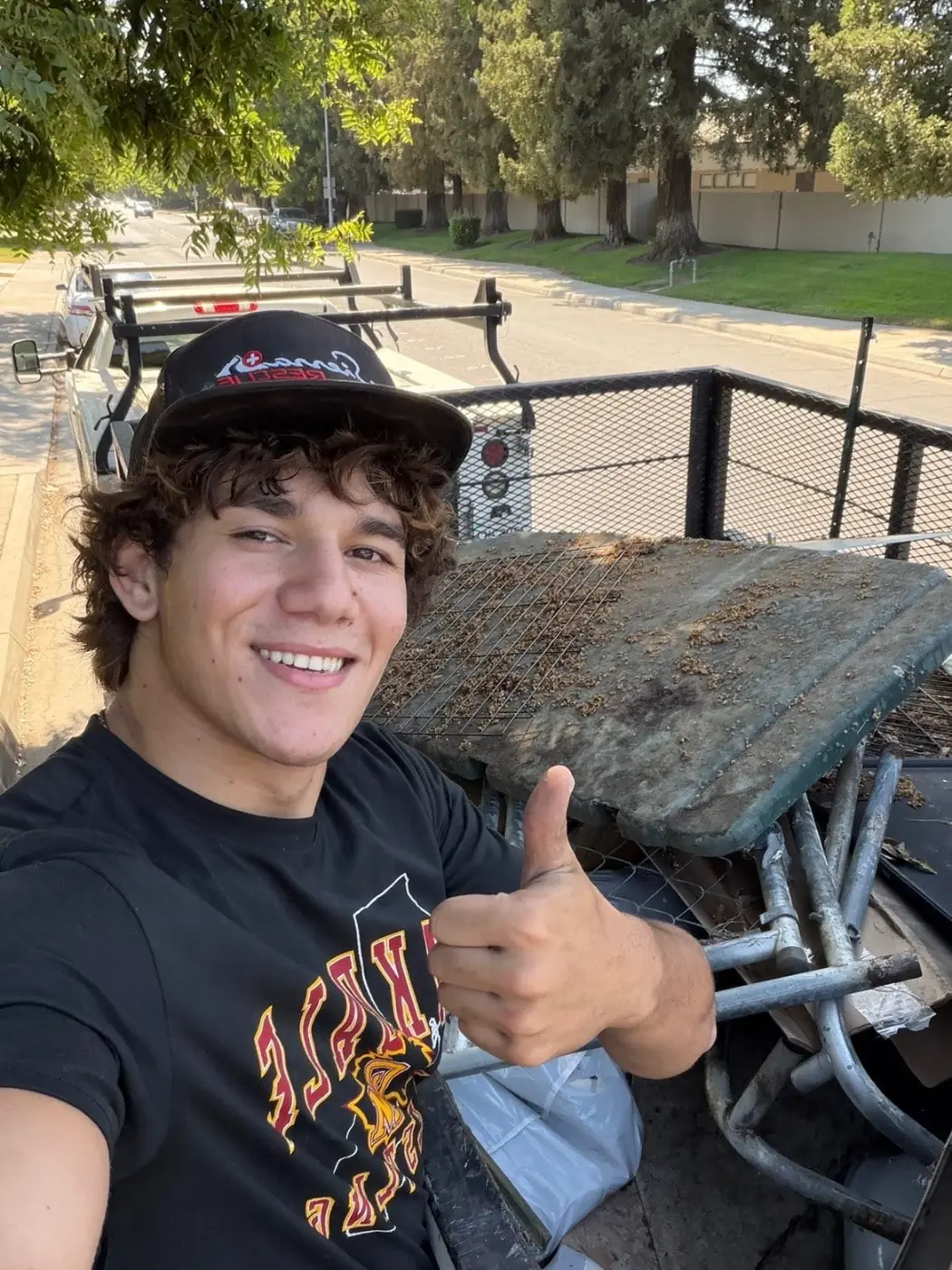 Jake smiling with a thumbs up next to a loaded trailer