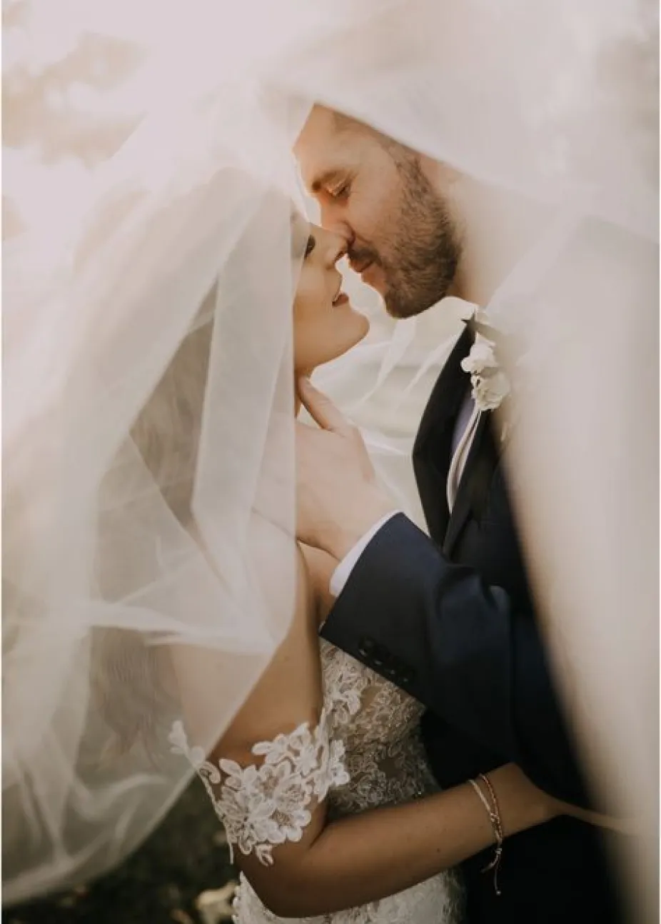 Groom kissing bride under her veil