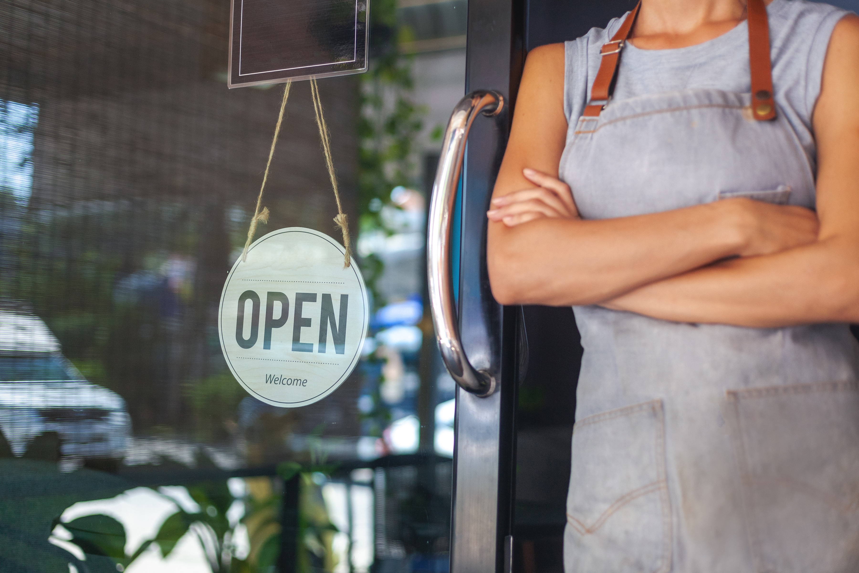 Small business owner in an apron standing in her shop