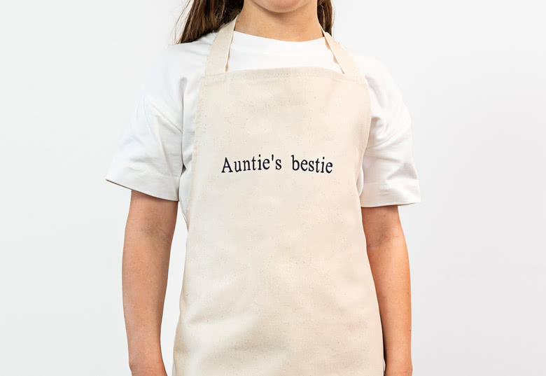 Kinderschürze bestickt – Beige, Fairtrade-Baumwolle