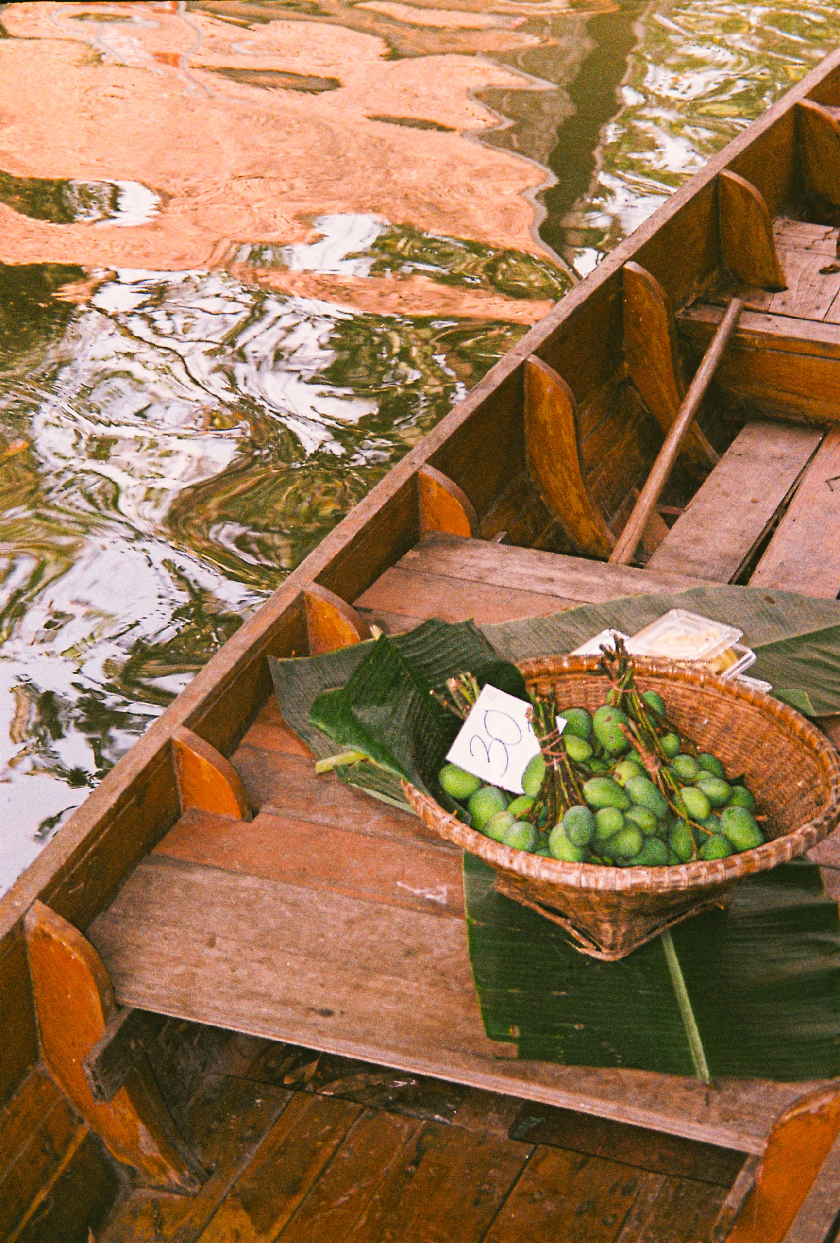 Barque d'un marché flottant, panier de fruits verts
