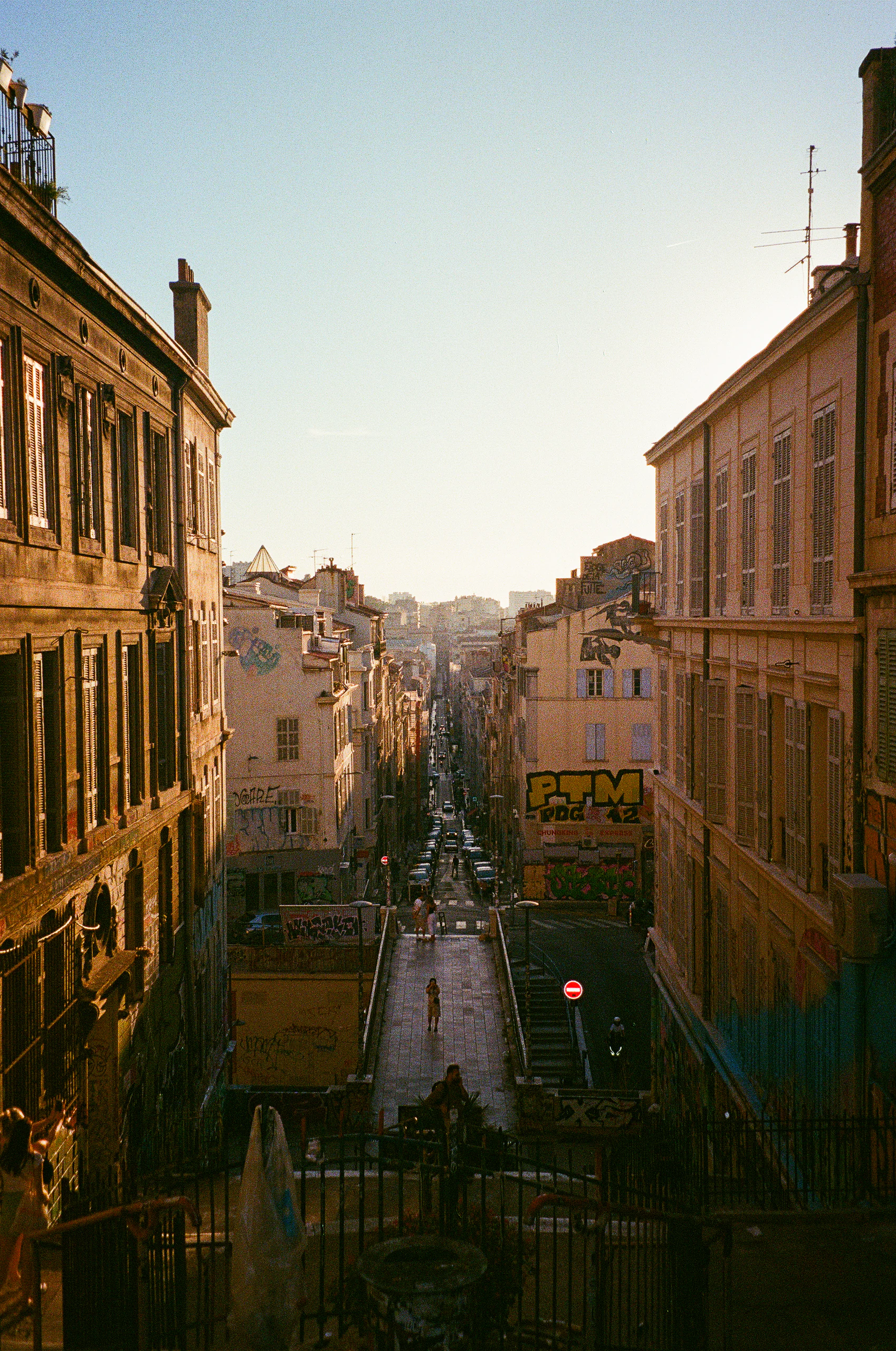 Rue en pente entre les façades, au soleil couchant