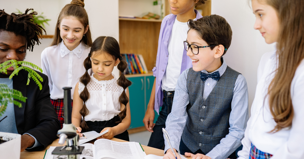 Students gathered around a microscope in a classroom