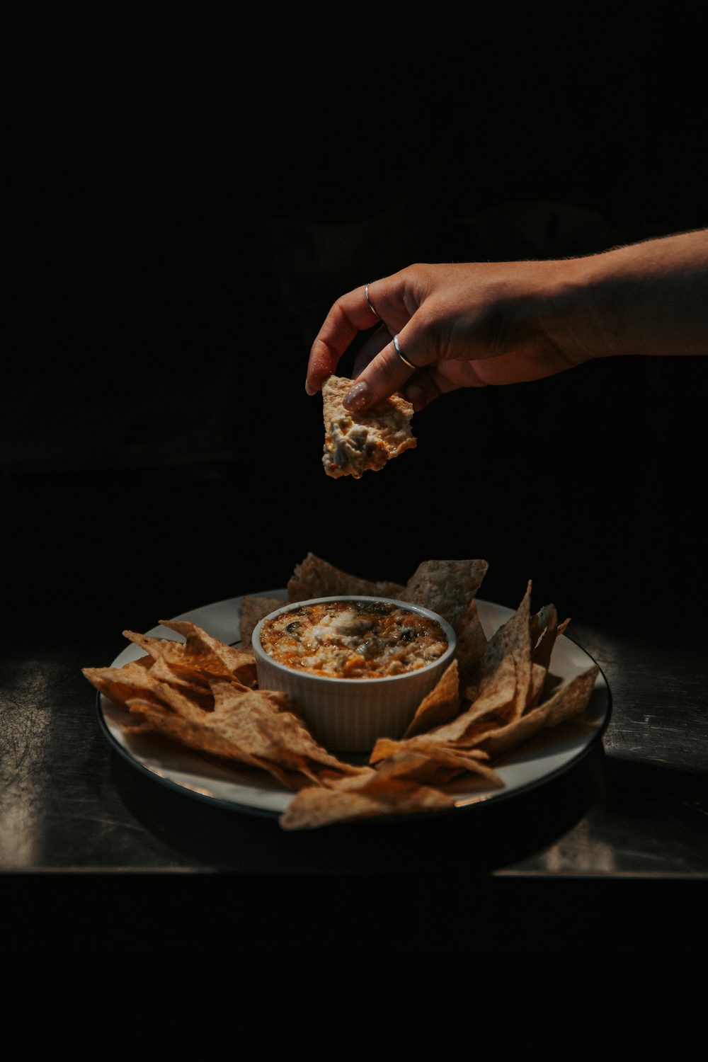 Chip being dipped into a bowl of dip