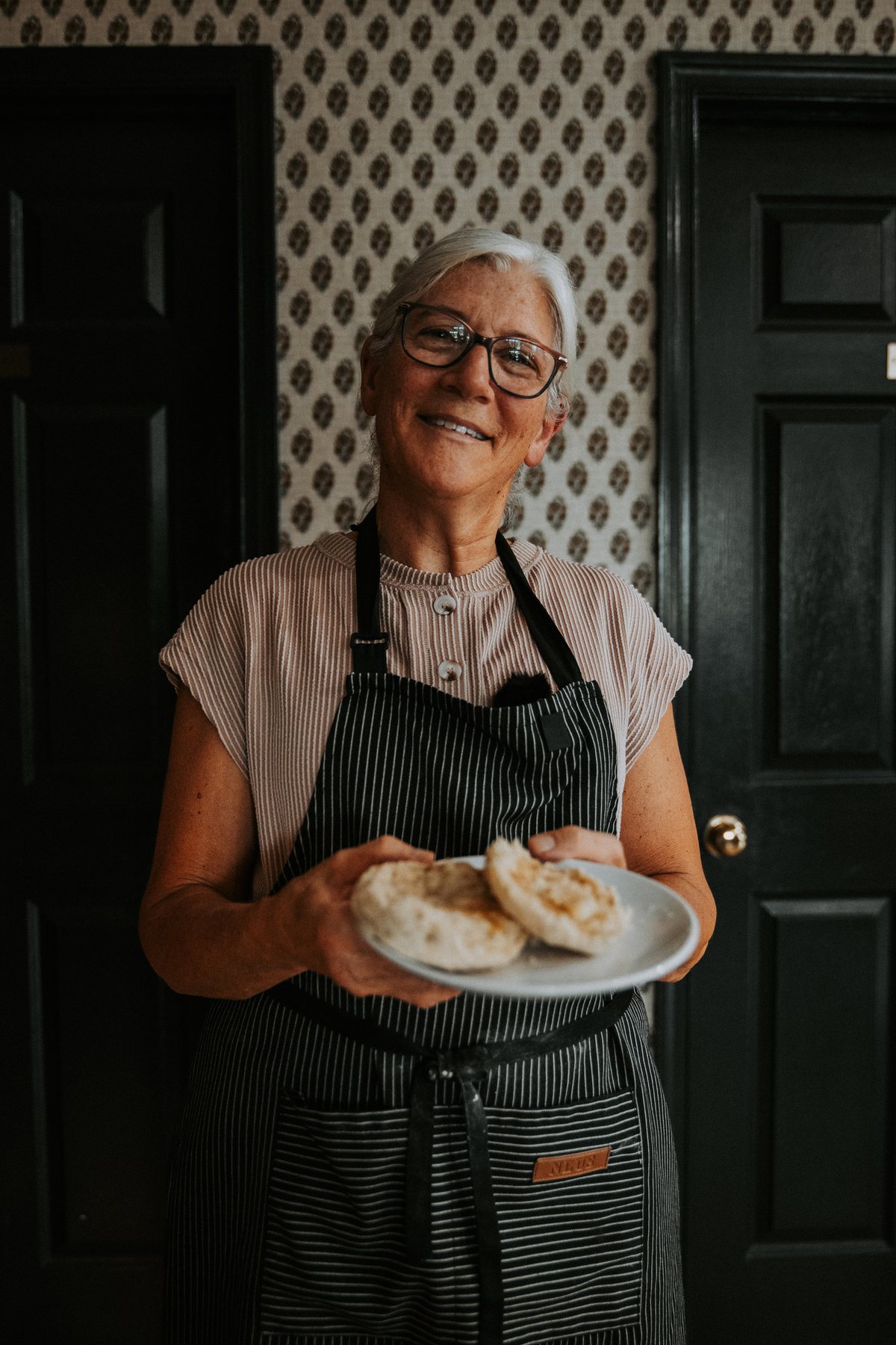 Baker holding a plate of fresh biscuits