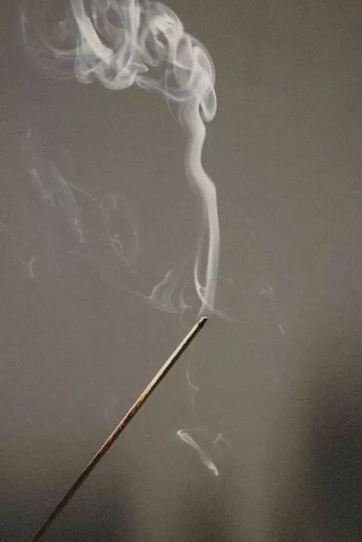 A thin ribbon of incense smoke rising