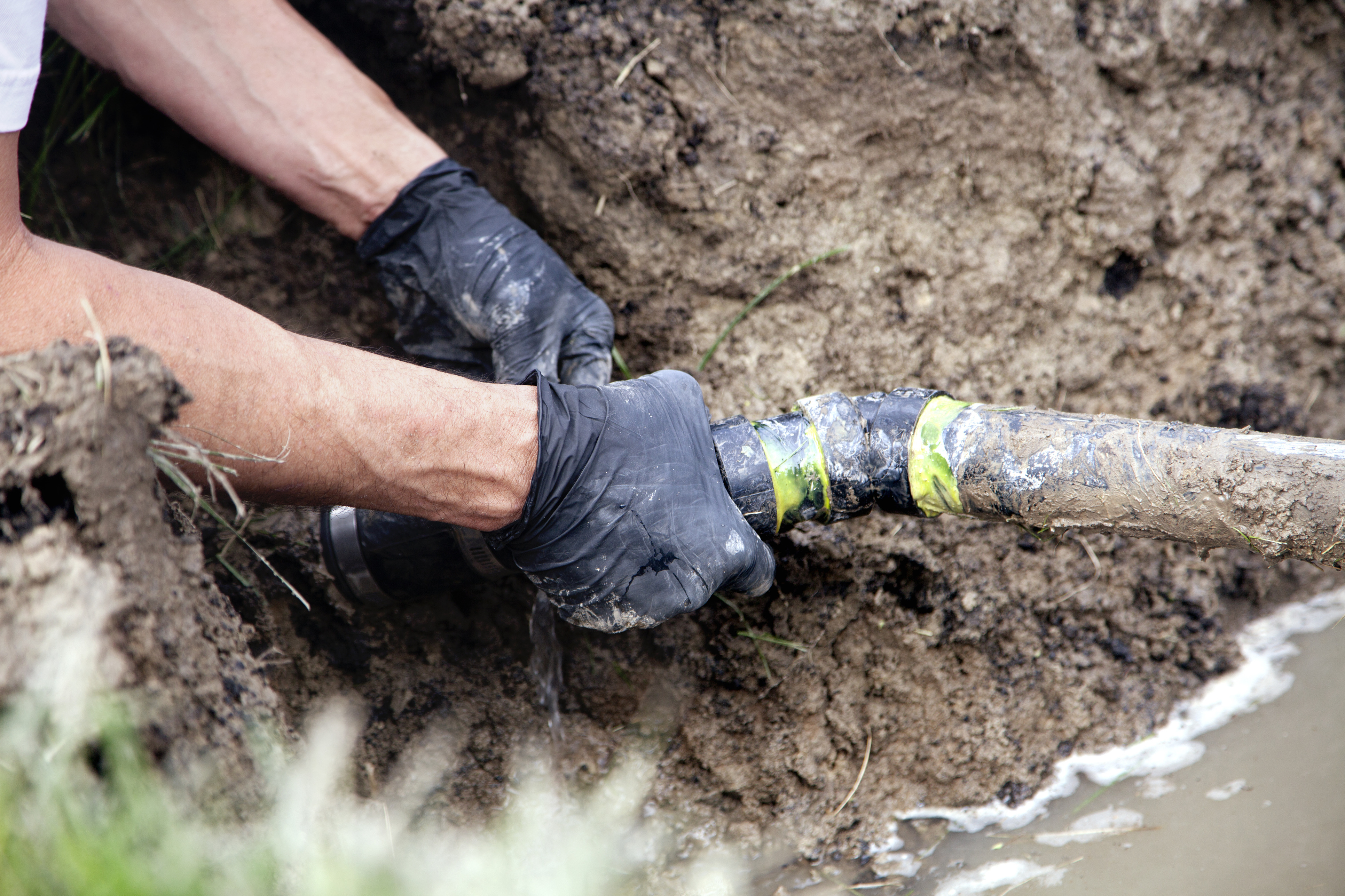 Drainlayer repairing a damaged drain pipe