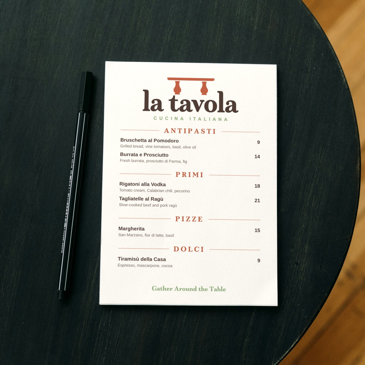 La Tavola dinner menu on a dark round cafe table