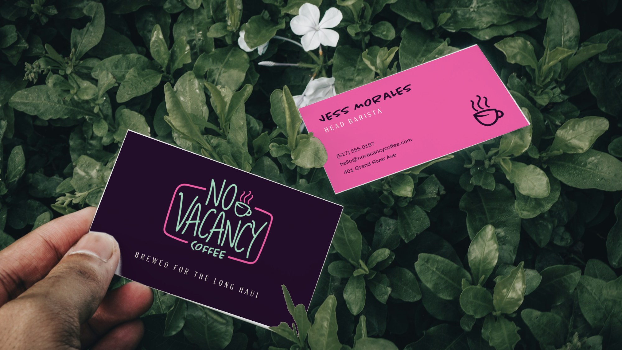 No Vacancy business cards, front and back, held over green leaves