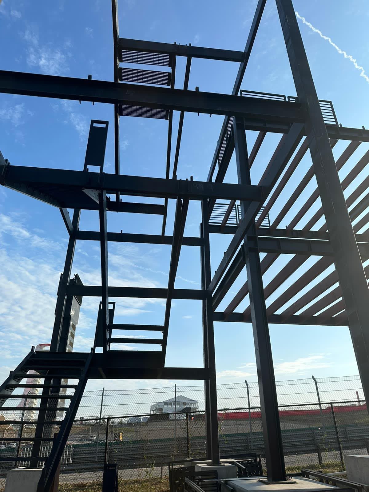 The steel frame, stairs and decks seen from below during assembly