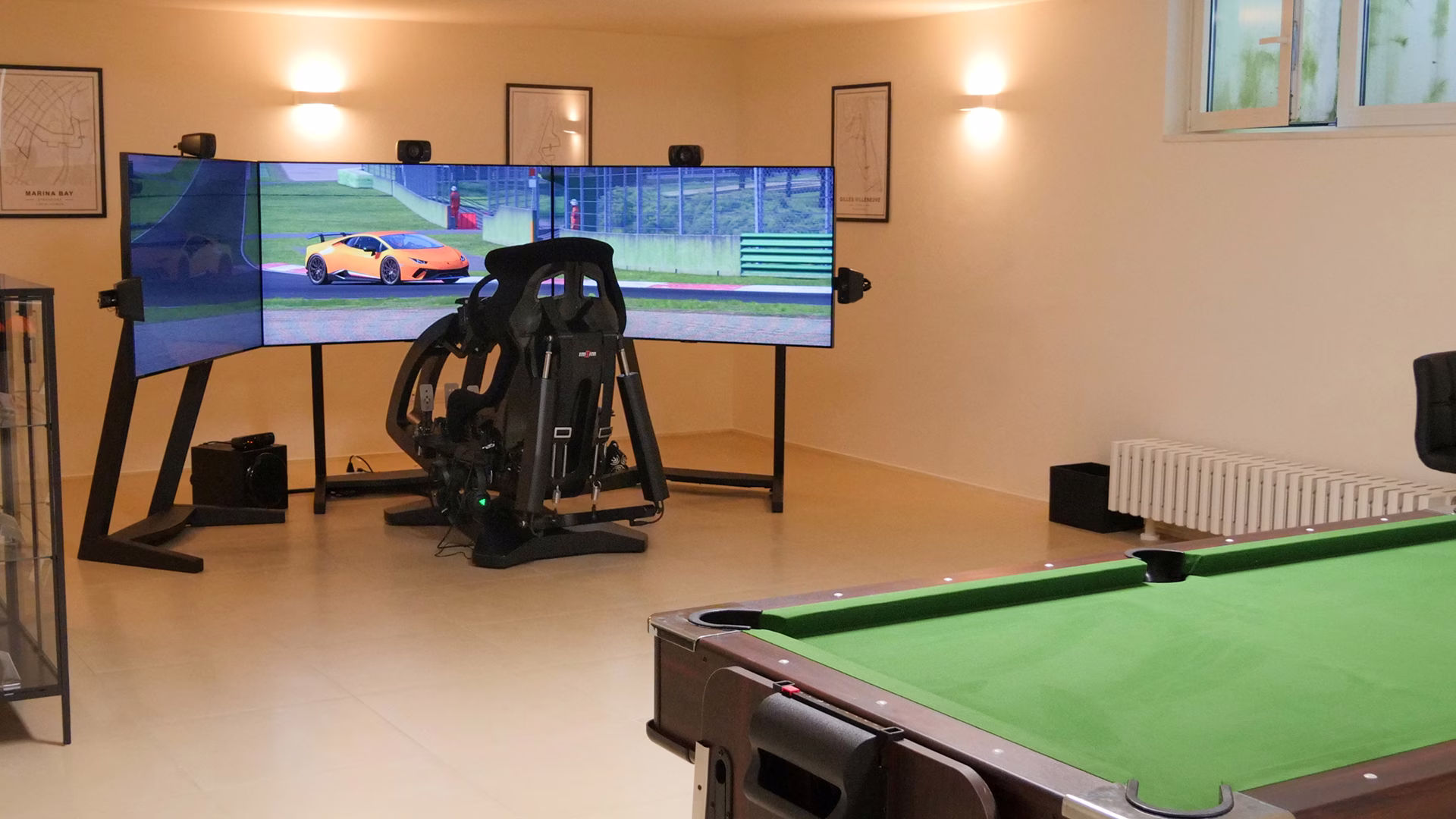An ImSim simulator with three screens in a private games room at home, beside a snooker table.