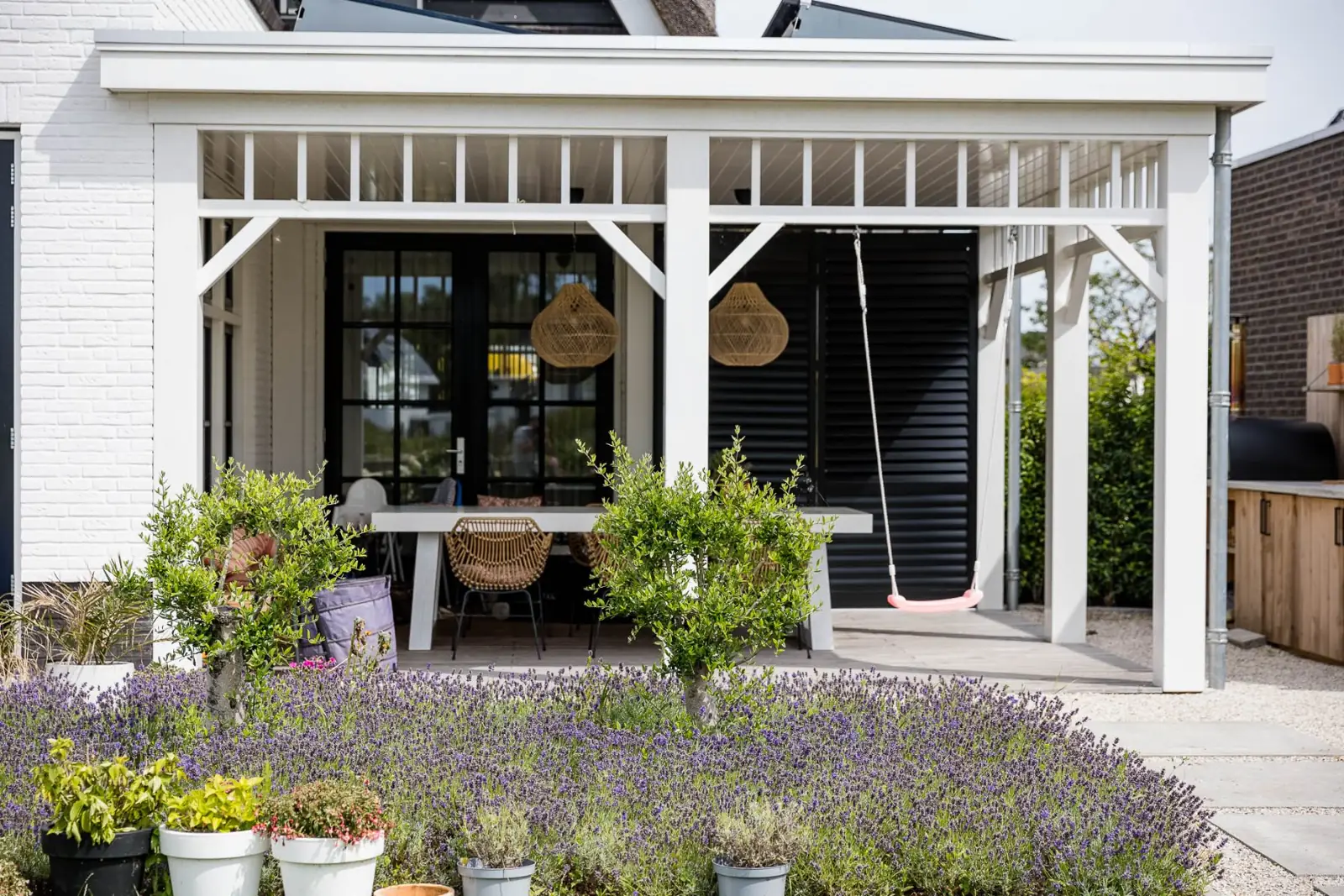Veranda lavendel olijfboompjes schommel in een tuin in Lelystad