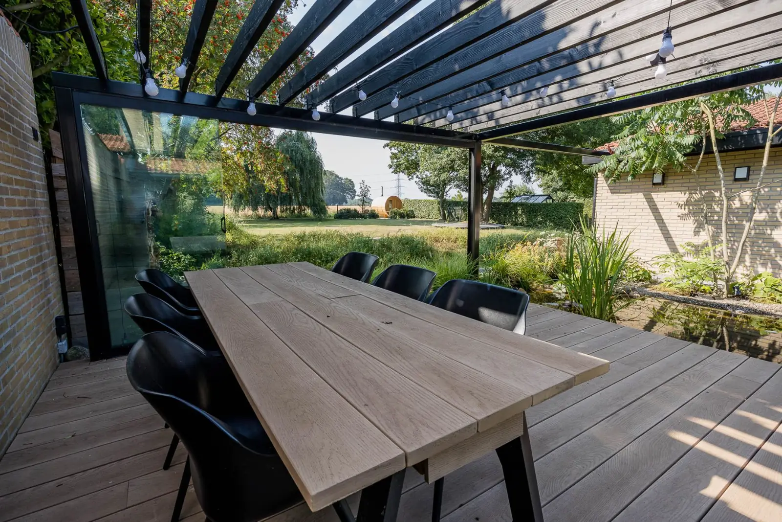 Pergola eettafel uitzicht sauna in een tuin in Enschede