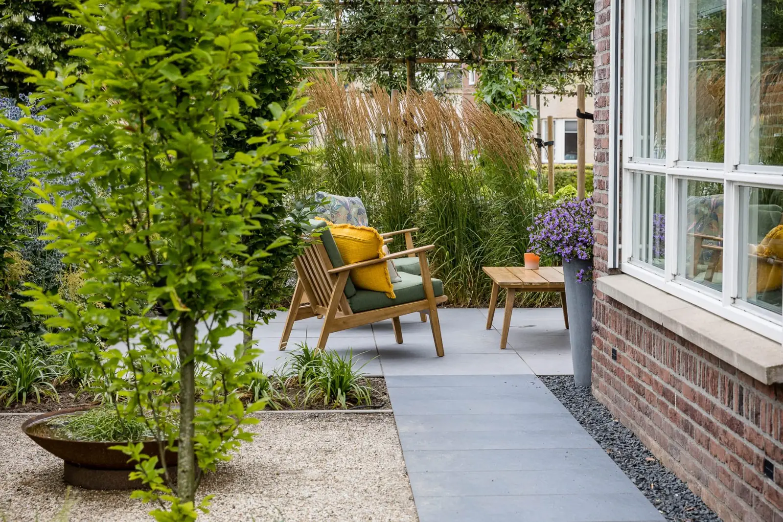 Loungestoel siergras doorkijk in een tuin in Dalfsen