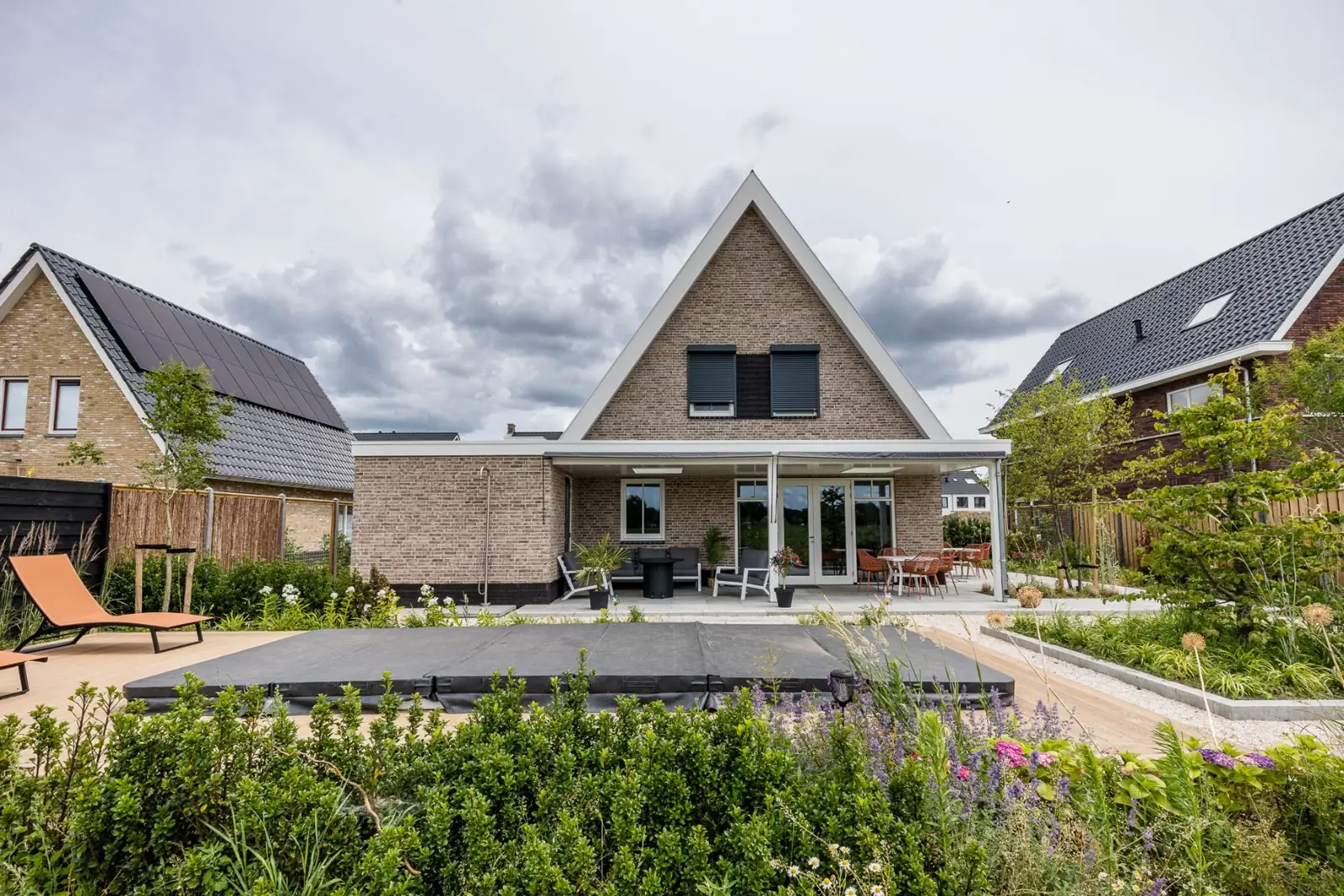 Achtergevel van de woning met overkapping en jacuzzi in een tuin in Hardenberg