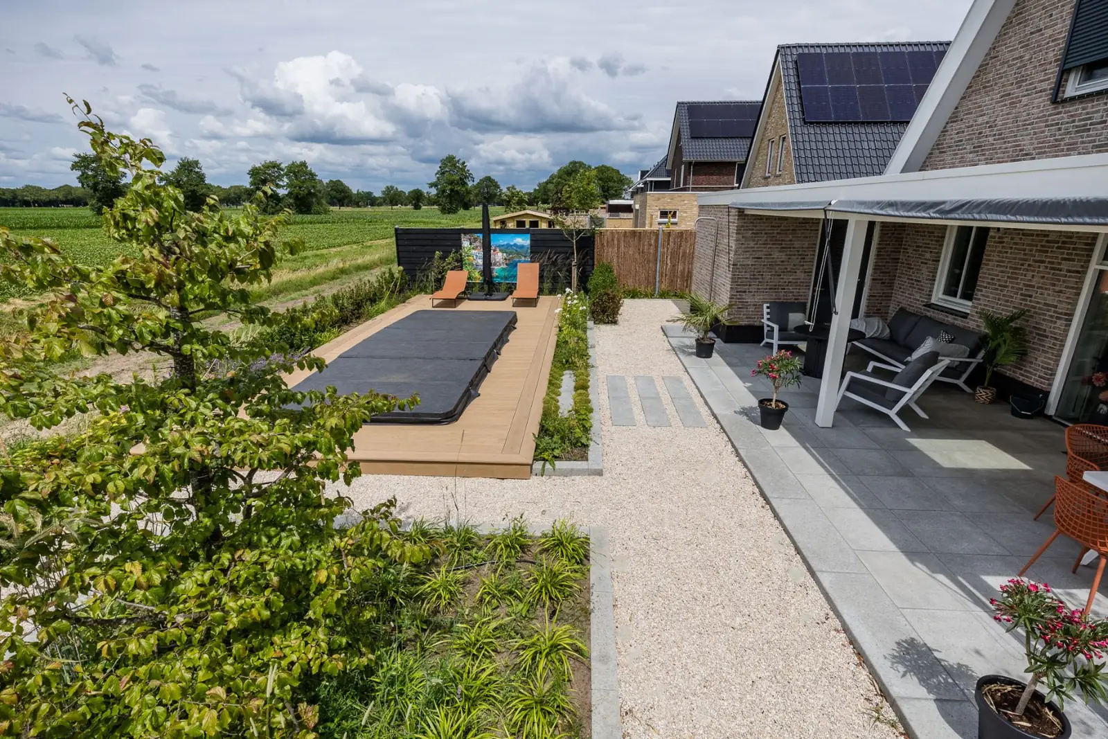 Jacuzzi op een composietvlonder naast het terras met overkapping in Hardenberg