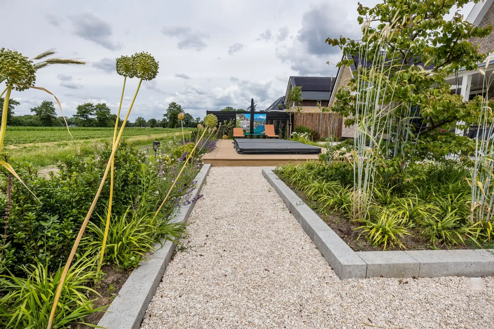 Grindpad tussen sierui en vaste planten richting de jacuzzi in Hardenberg