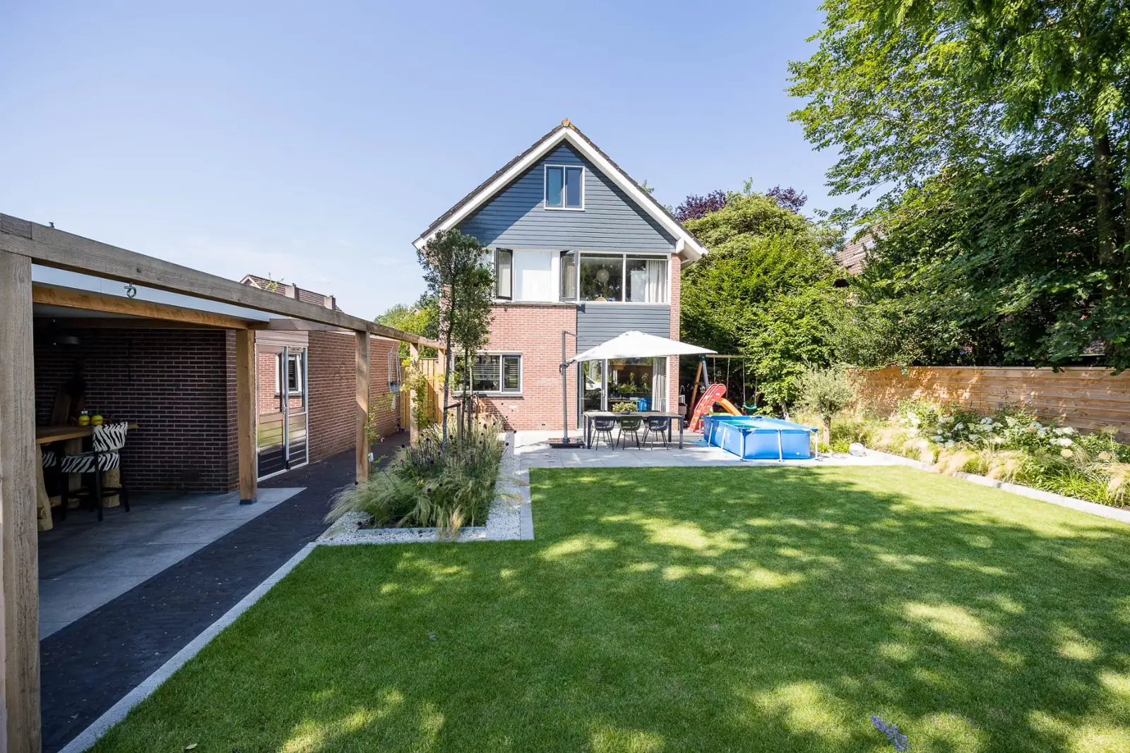 Achtertuin woning terras gazon borders in een tuin in Hardenberg