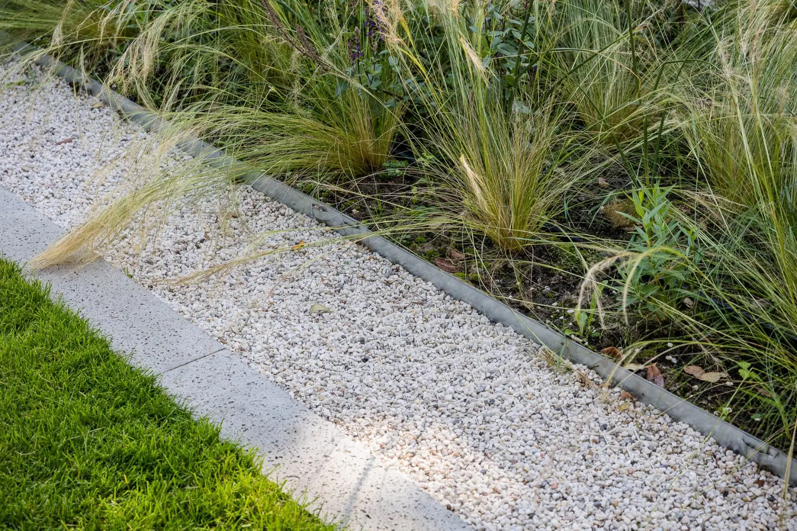 Grindstrook grindmatten stalen rand detail in een tuin in Hardenberg