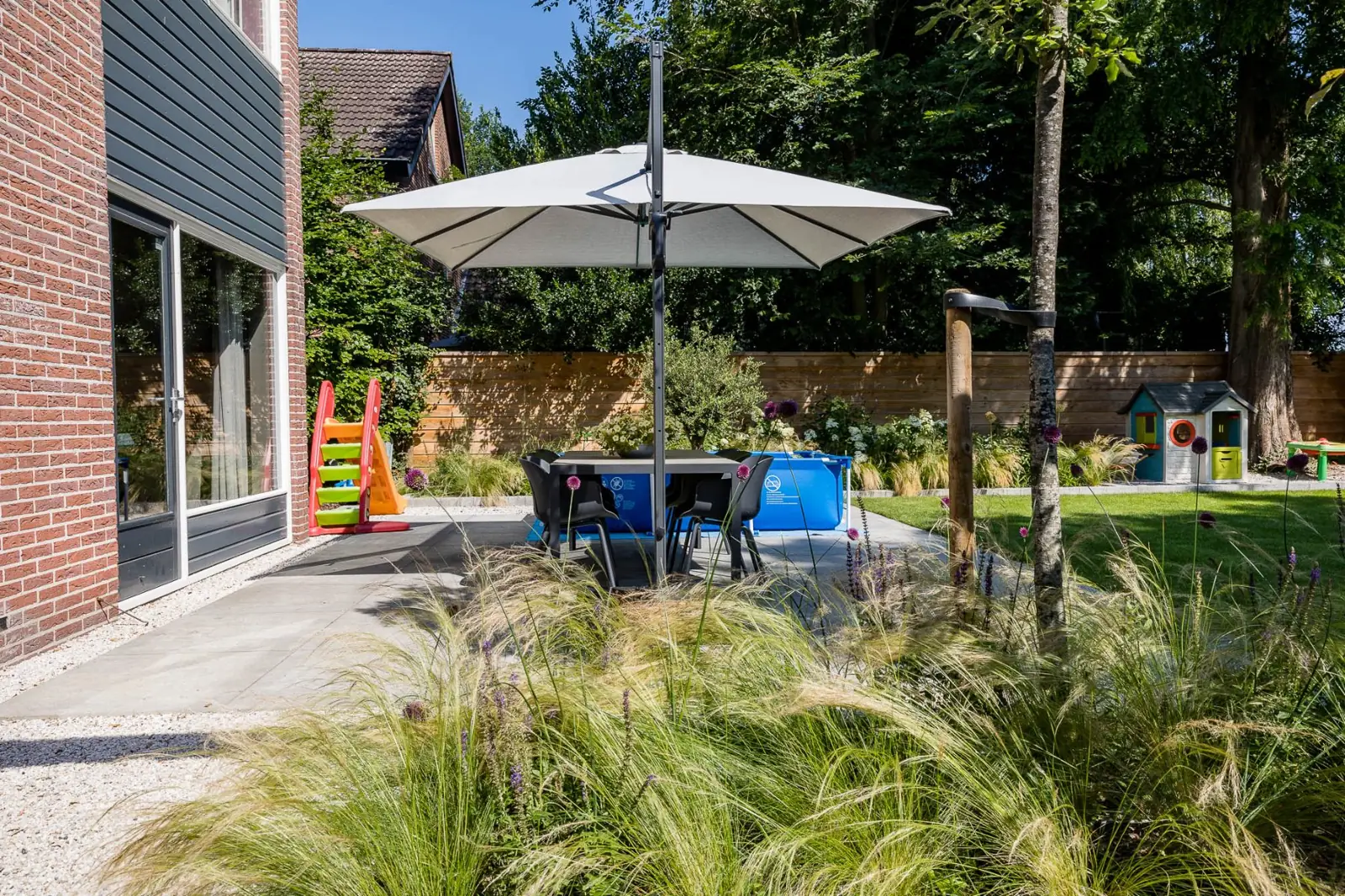 Terras parasol eettafel vedergras in een tuin in Hardenberg