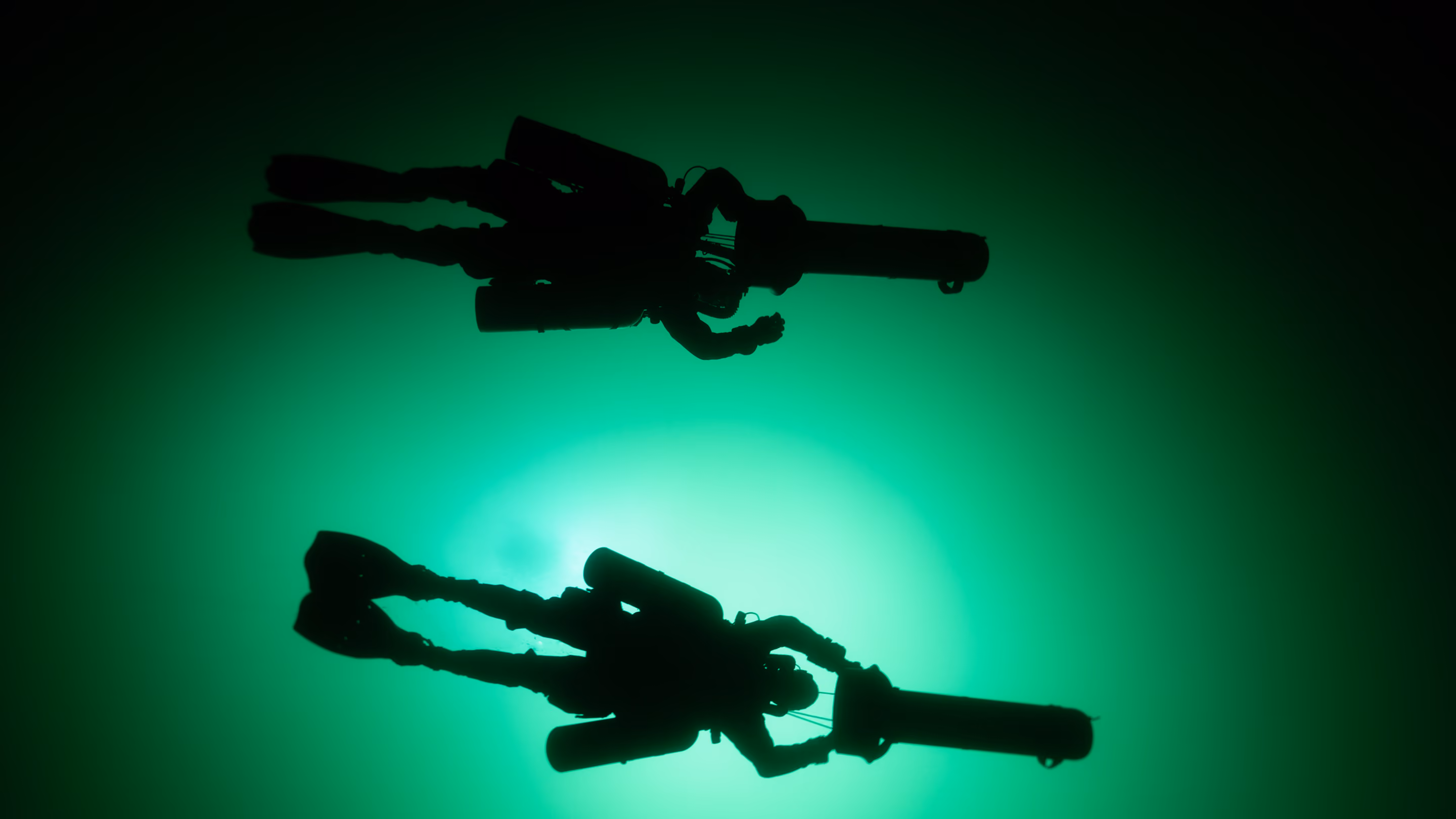 silhouette of 2 divers underwater 