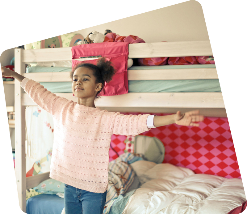 A child playing beside a wooden bunk bed