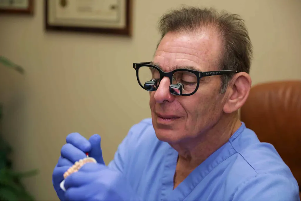 Doctor crafting a custom dental restoration on a model