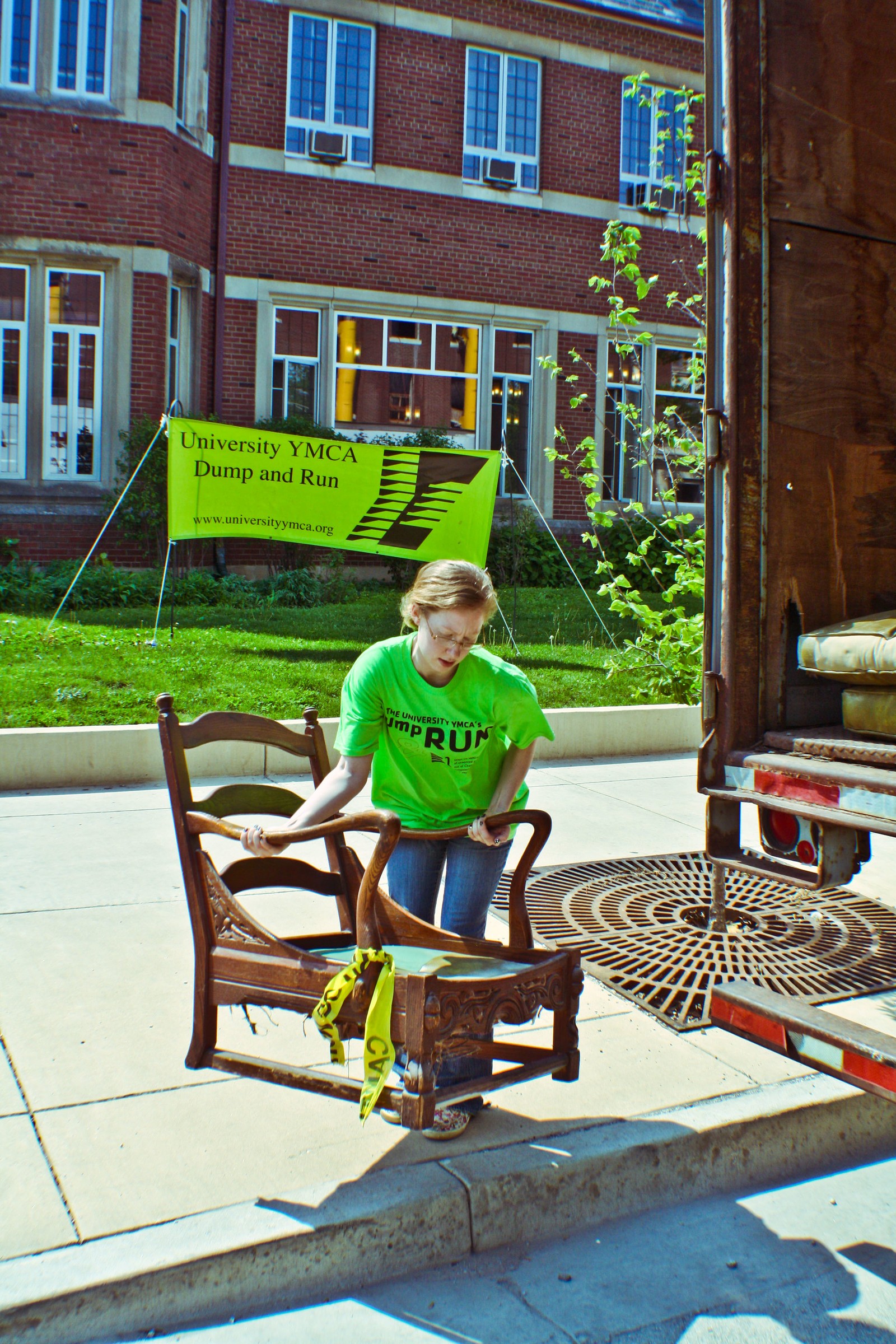 A volunteer carries an antique chair to the storage truck outside the University YMCA during the May collections, May 10, 2011. University YMCA photograph.
