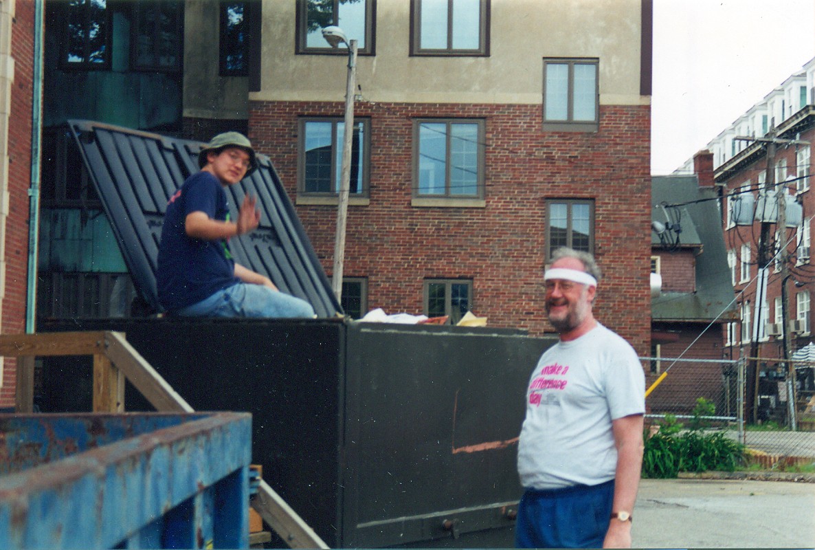 Steve Shoemaker (right), in a "Make a Difference Day" T-shirt, with a volunteer at a collection dumpster, 2000s. University YMCA photograph.